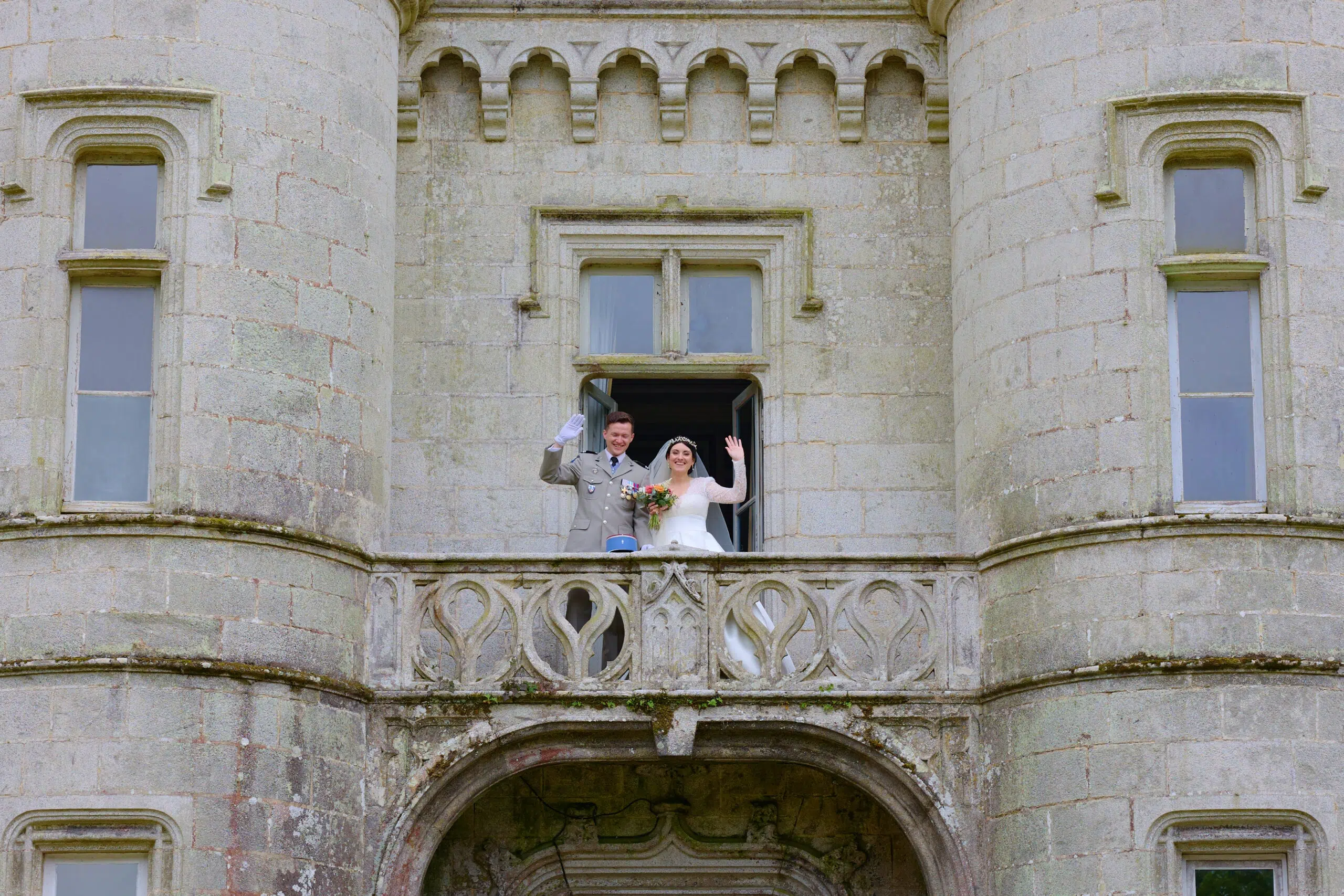 The newlyweds walking through the château grounds
