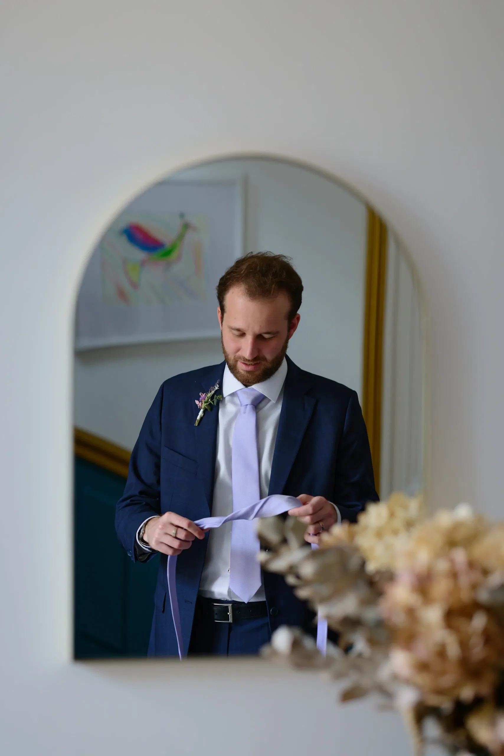 The groom adjusting his suit before the guests arrive