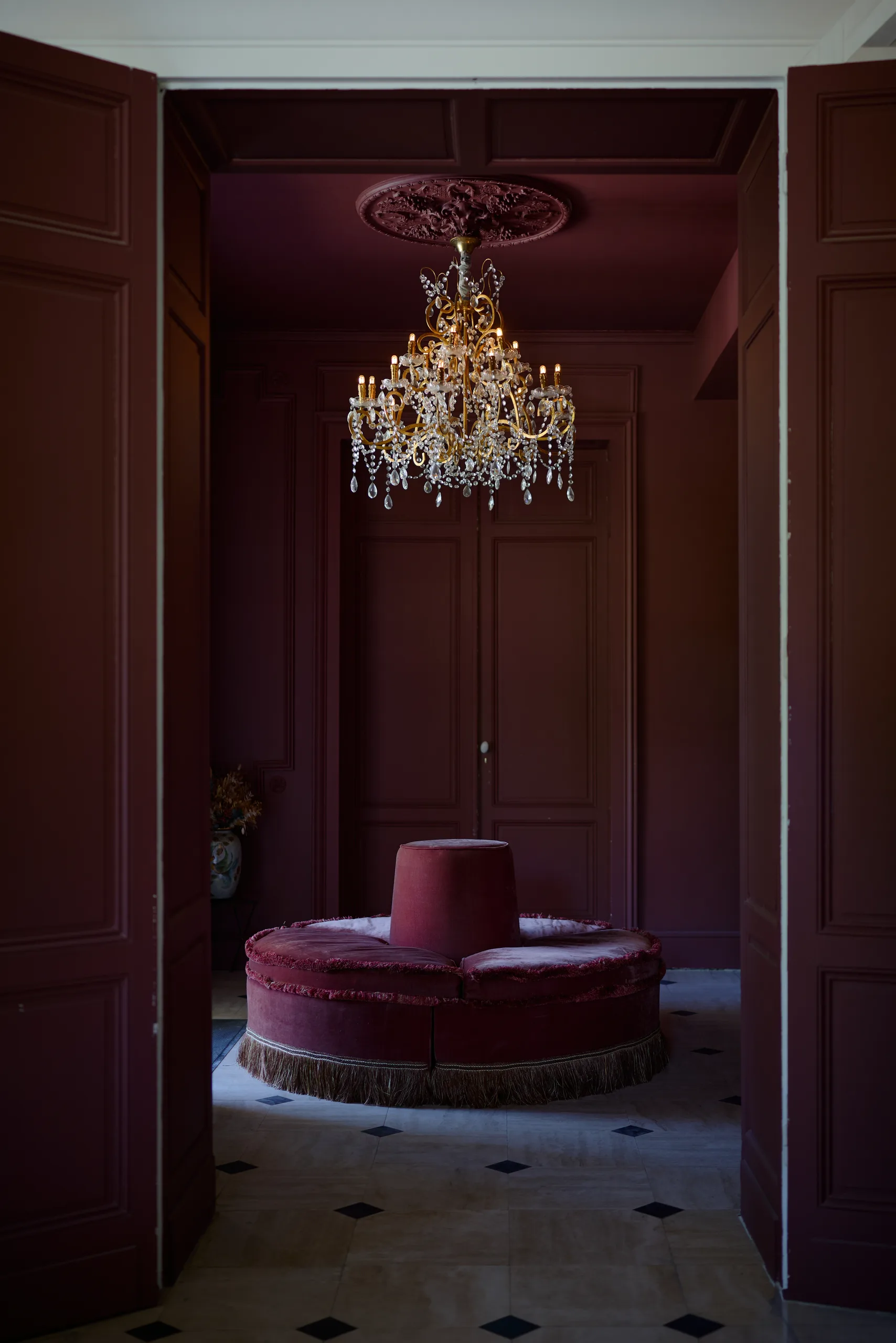 Lustre et fauteuil dans une chambre du Château Léognan