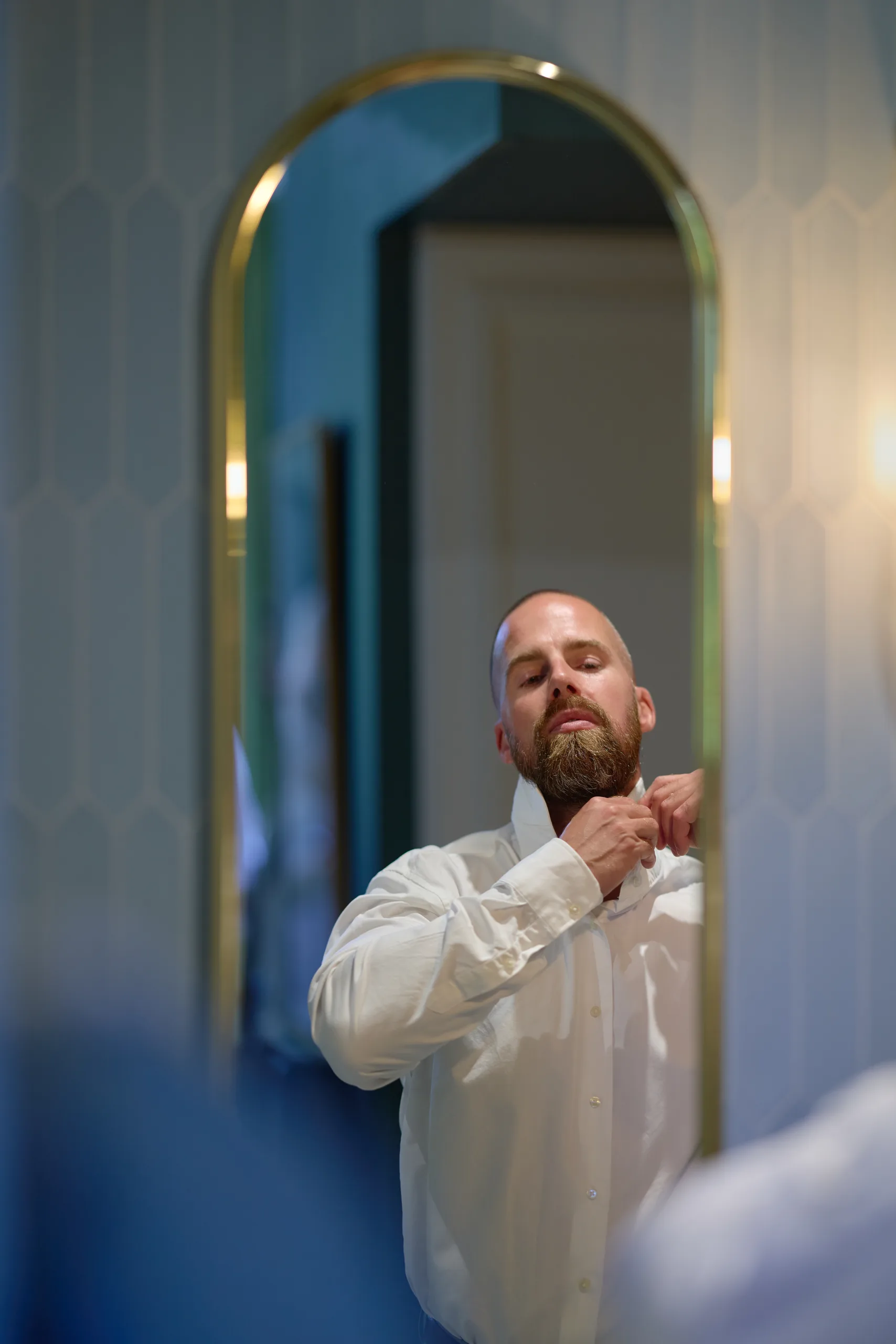 Dimitri ajuste son col devant le miroir