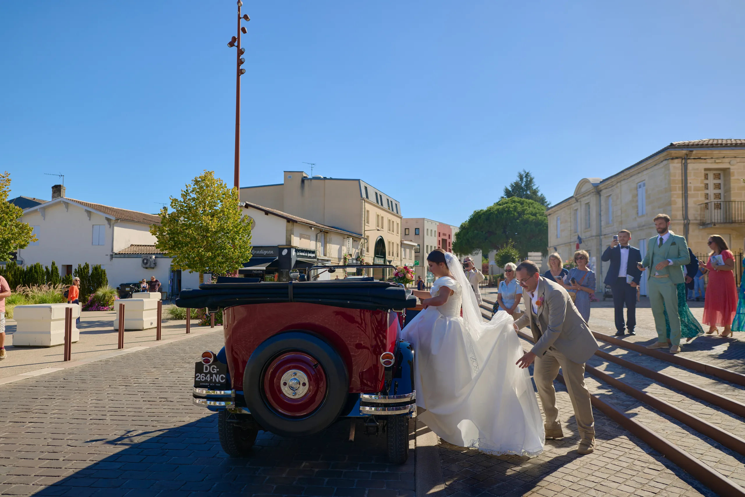 Les mariés et leur voiture ancienne devant l’église