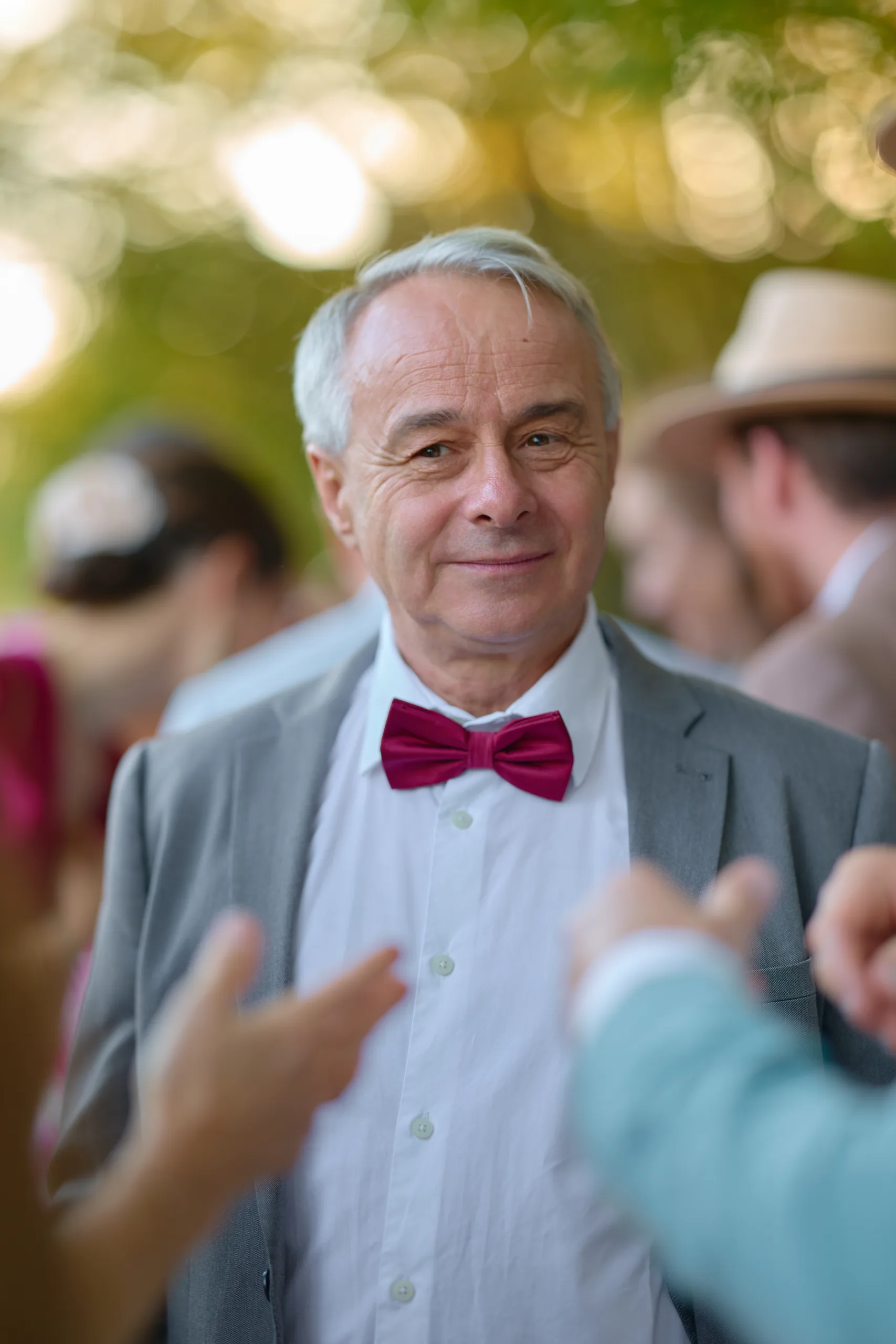 Un invité en nœud papillon rouge sourit au cocktail