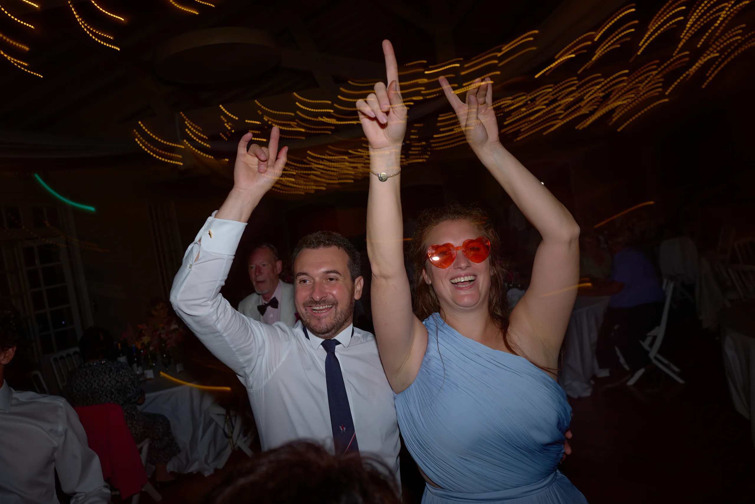 Deux invités lèvent les bras sur la piste de danse