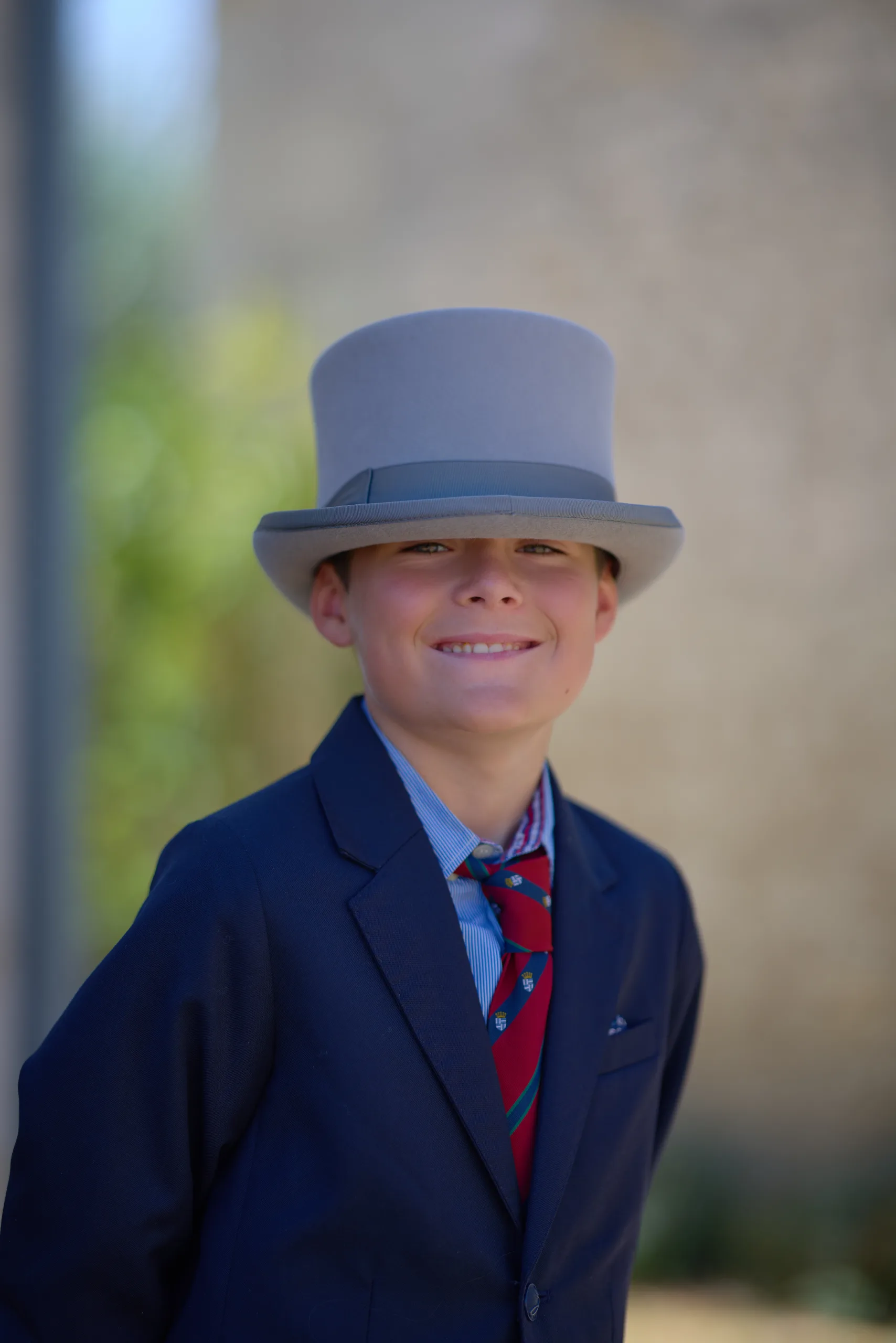 Un enfant en costume bleu et chapeau haut-de-forme