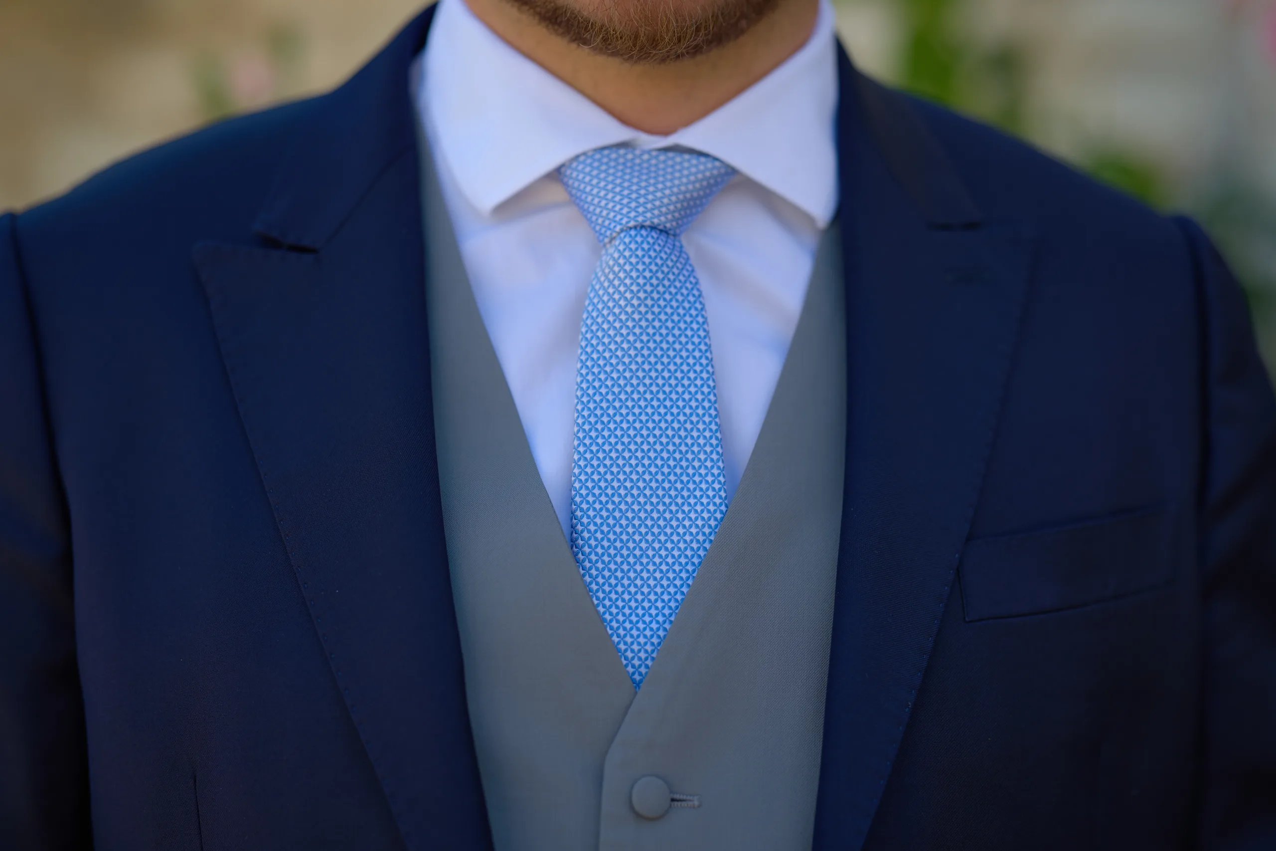 Détail d’une cravate bleu clair sur un costume bleu