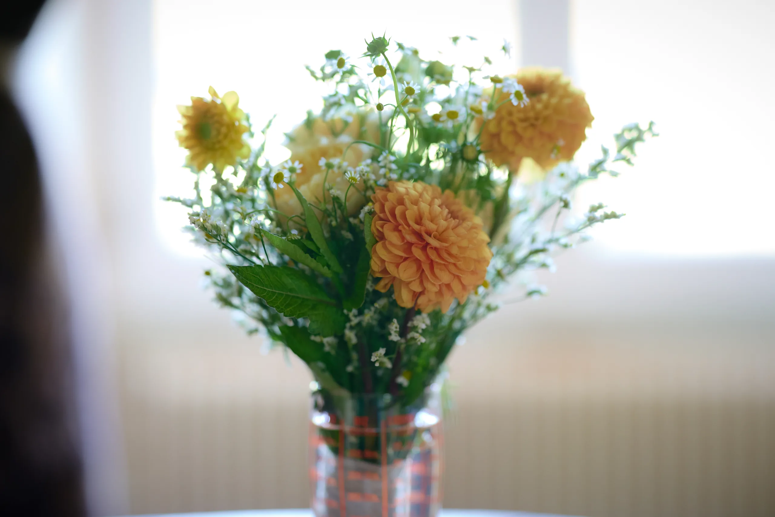 Bouquet de fleurs dans un vase près d’une fenêtre