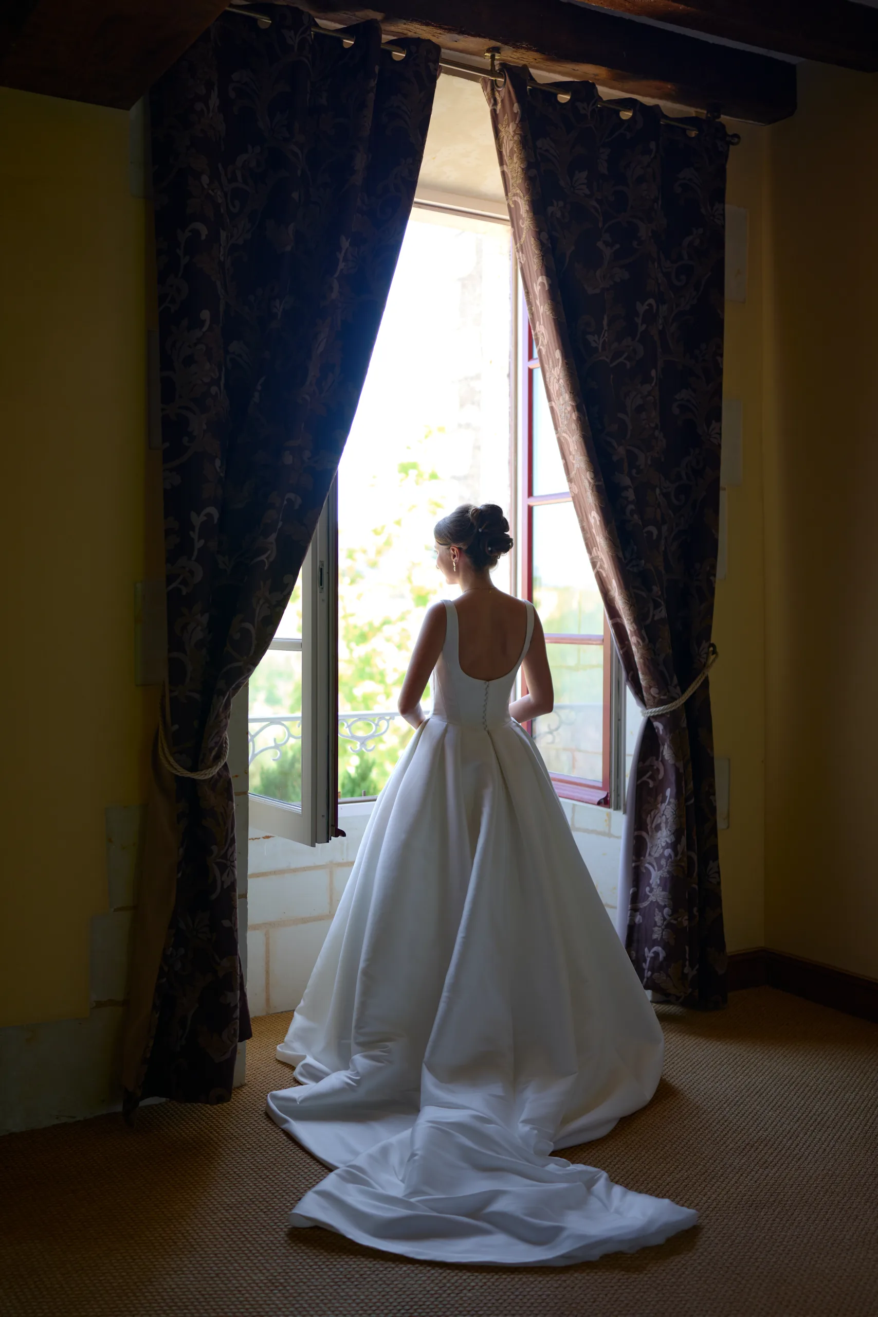 Femme en robe blanche devant une porte ouverte