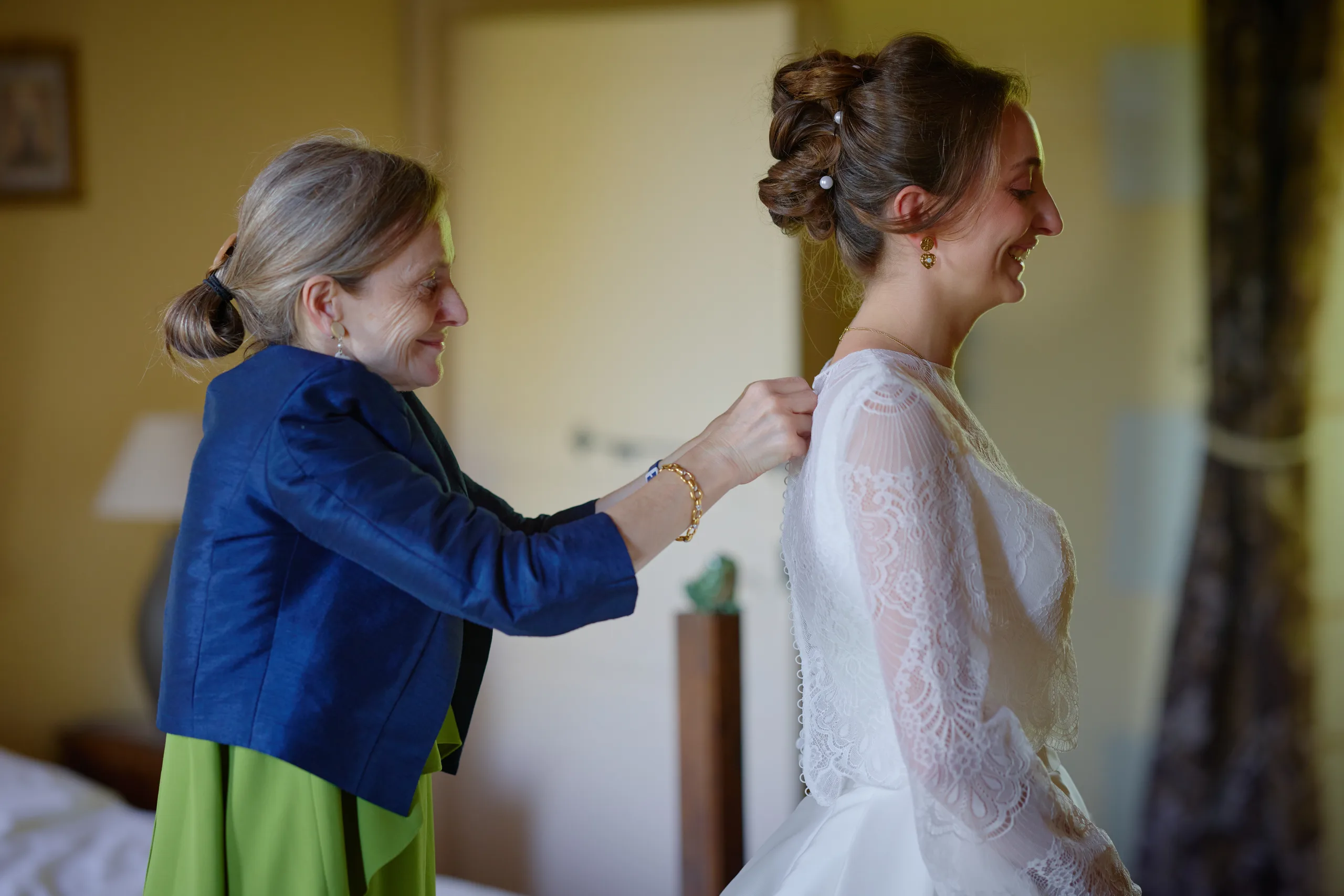 Une femme aide une autre à enfiler sa robe