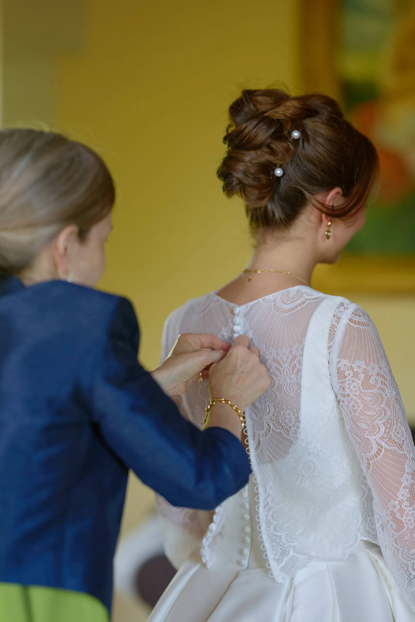 Une femme ajuste le dos d’une robe blanche
