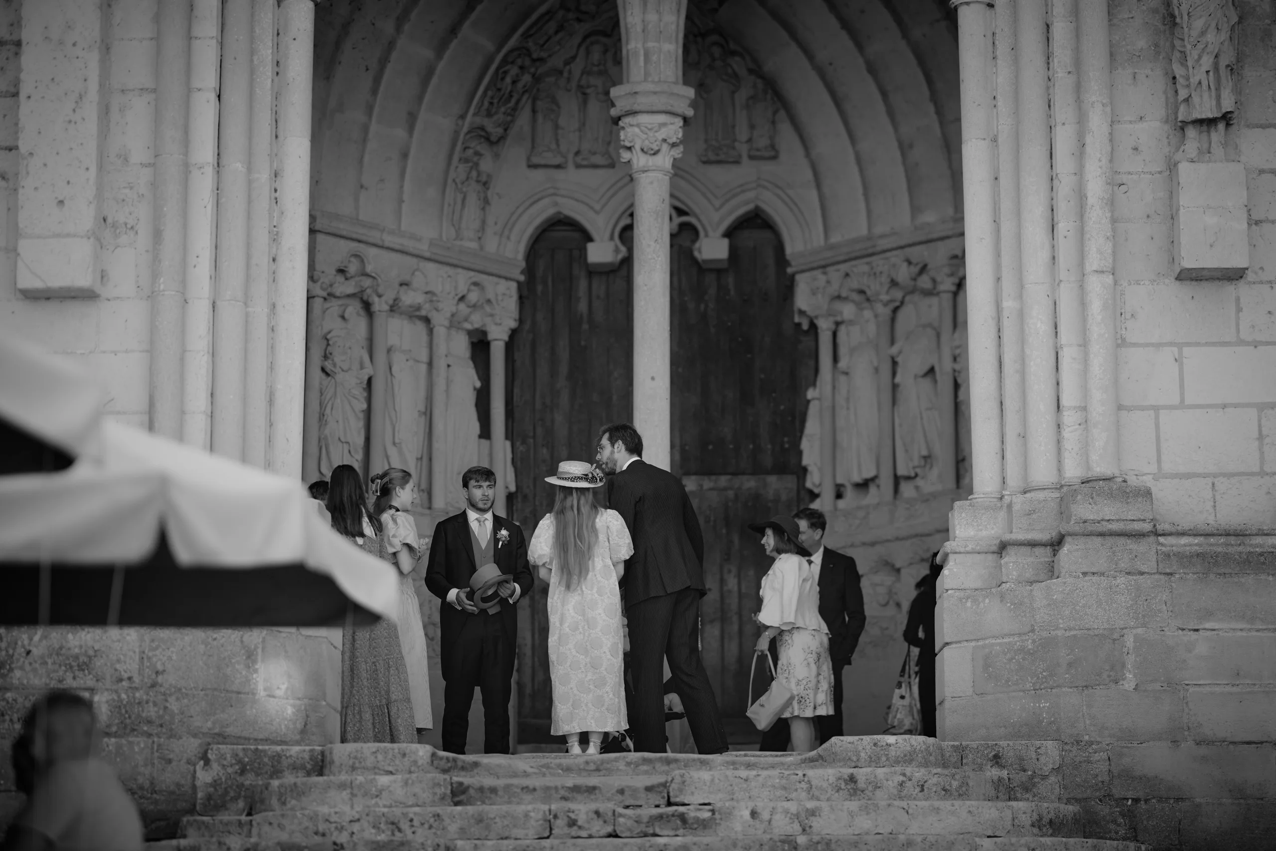 Groupe réuni sous le porche de l’église, en noir et blanc