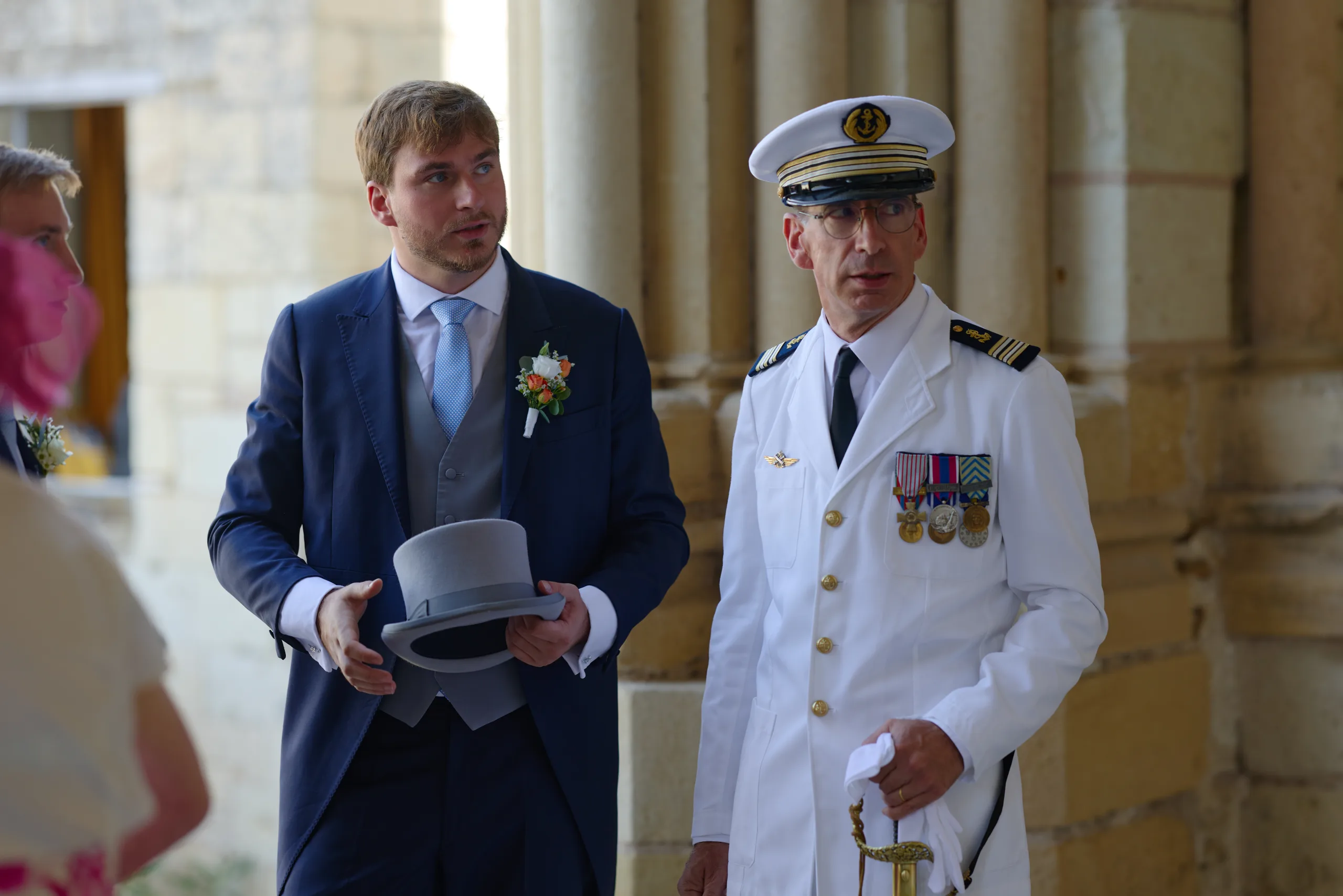 Un homme en costume pose avec un invité en uniforme