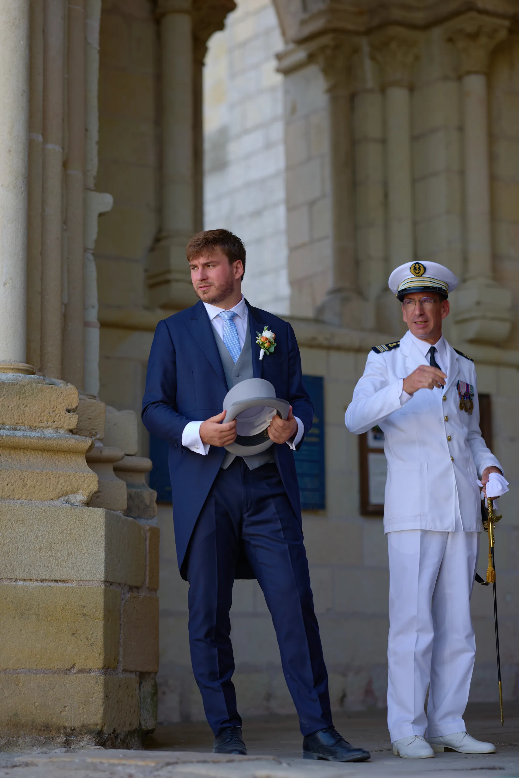 Deux hommes en costume et uniforme devant l’église