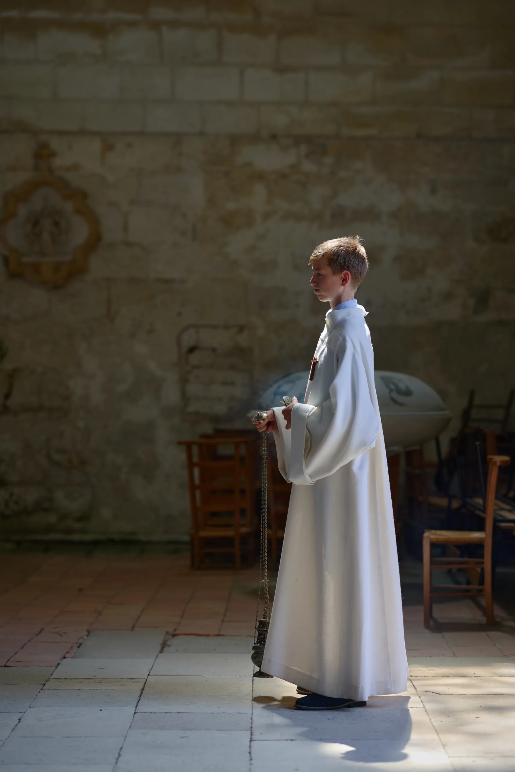 Femme en robe blanche près d’un mur de pierre