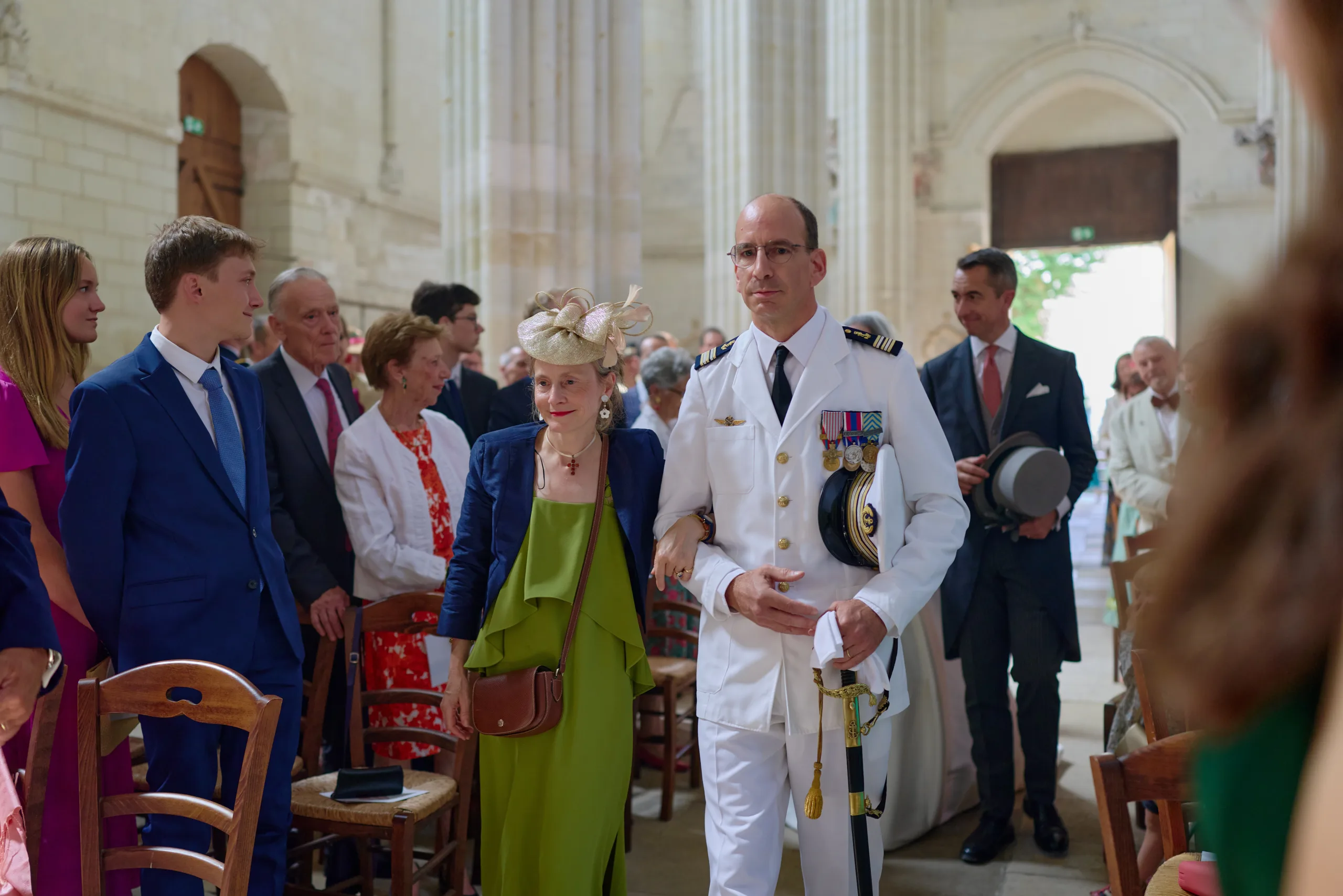 Un invité en uniforme marche dans l’allée de l’église