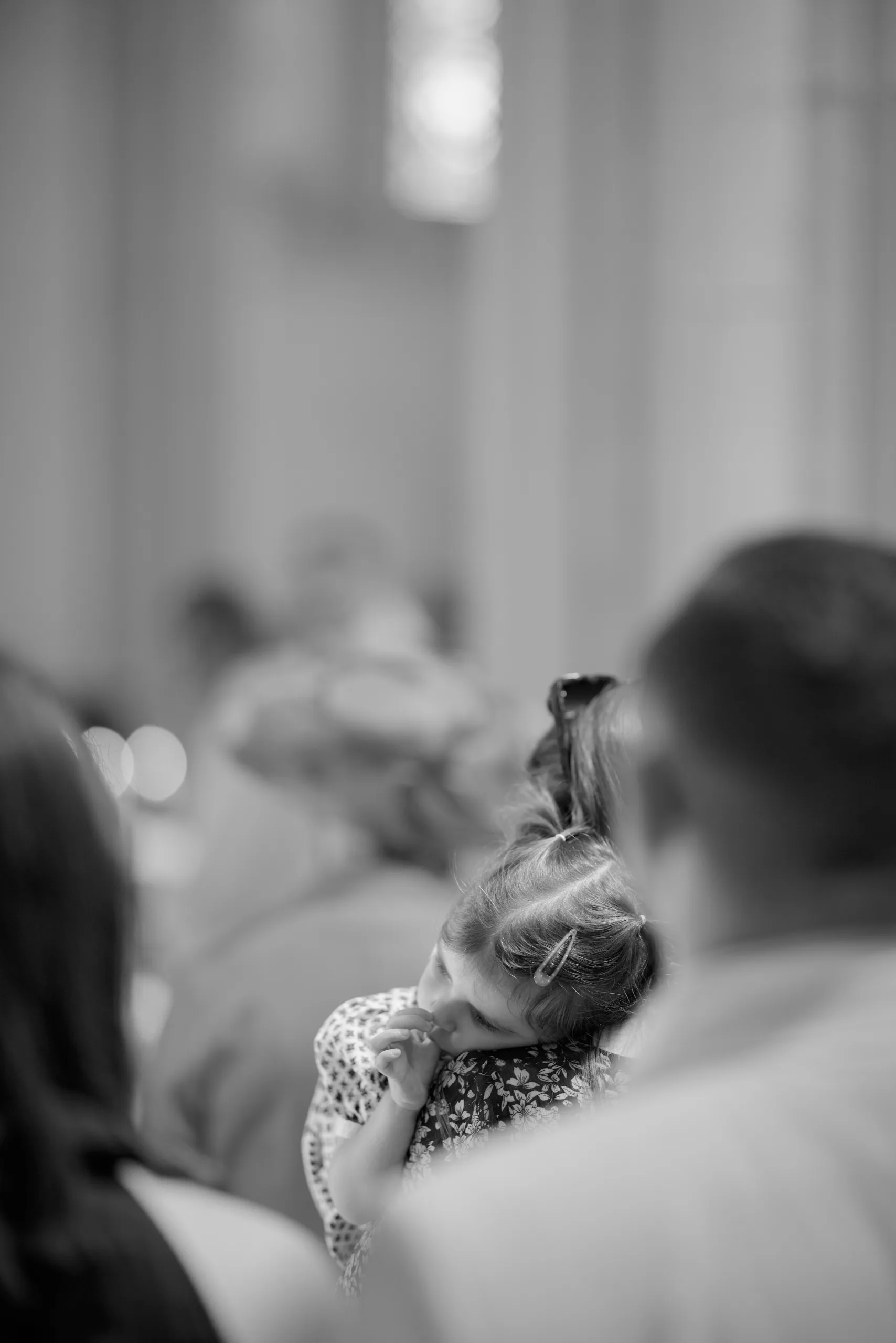 Un homme tient un bébé dans l’église, en noir et blanc