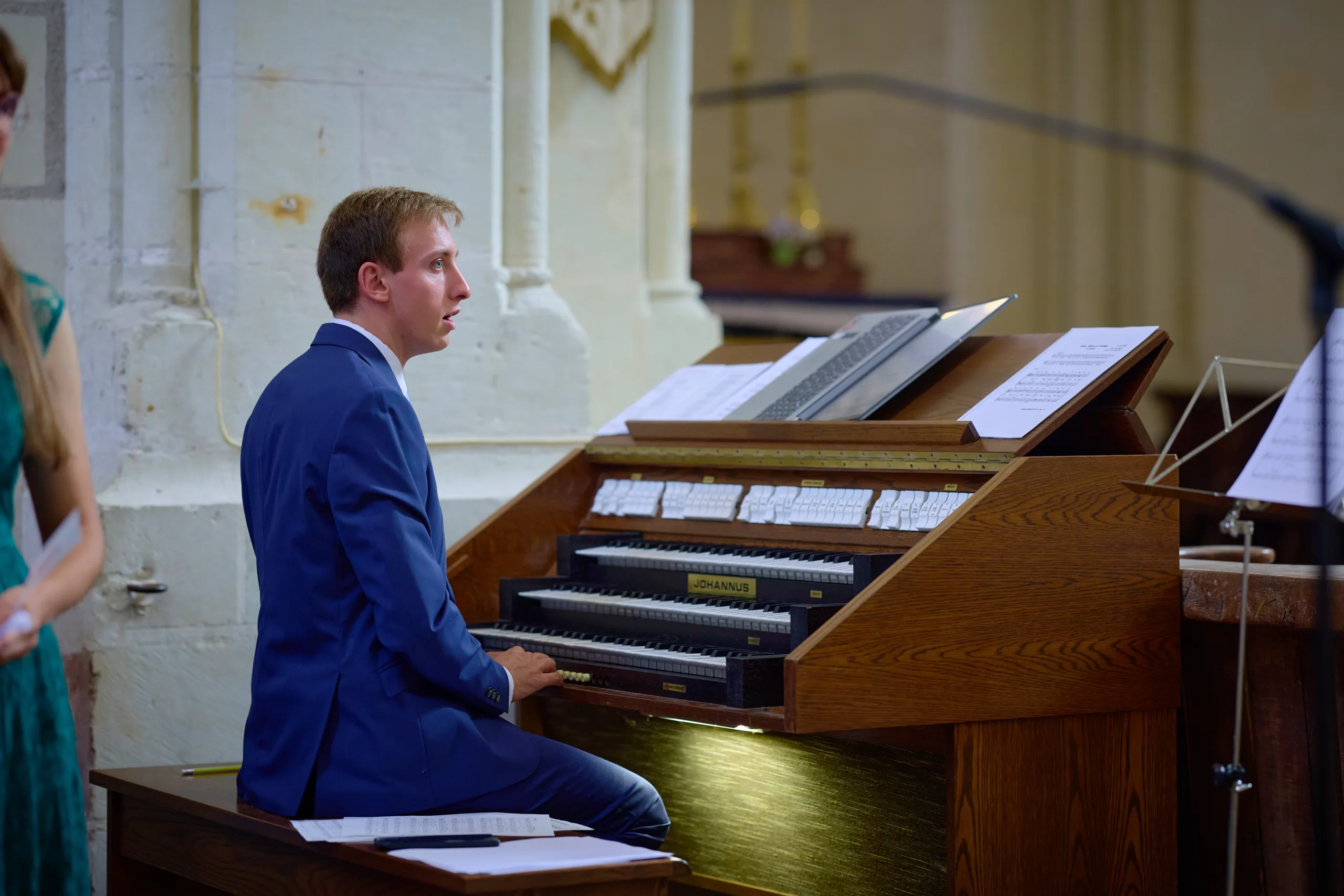Homme en costume jouant du piano dans l’église
