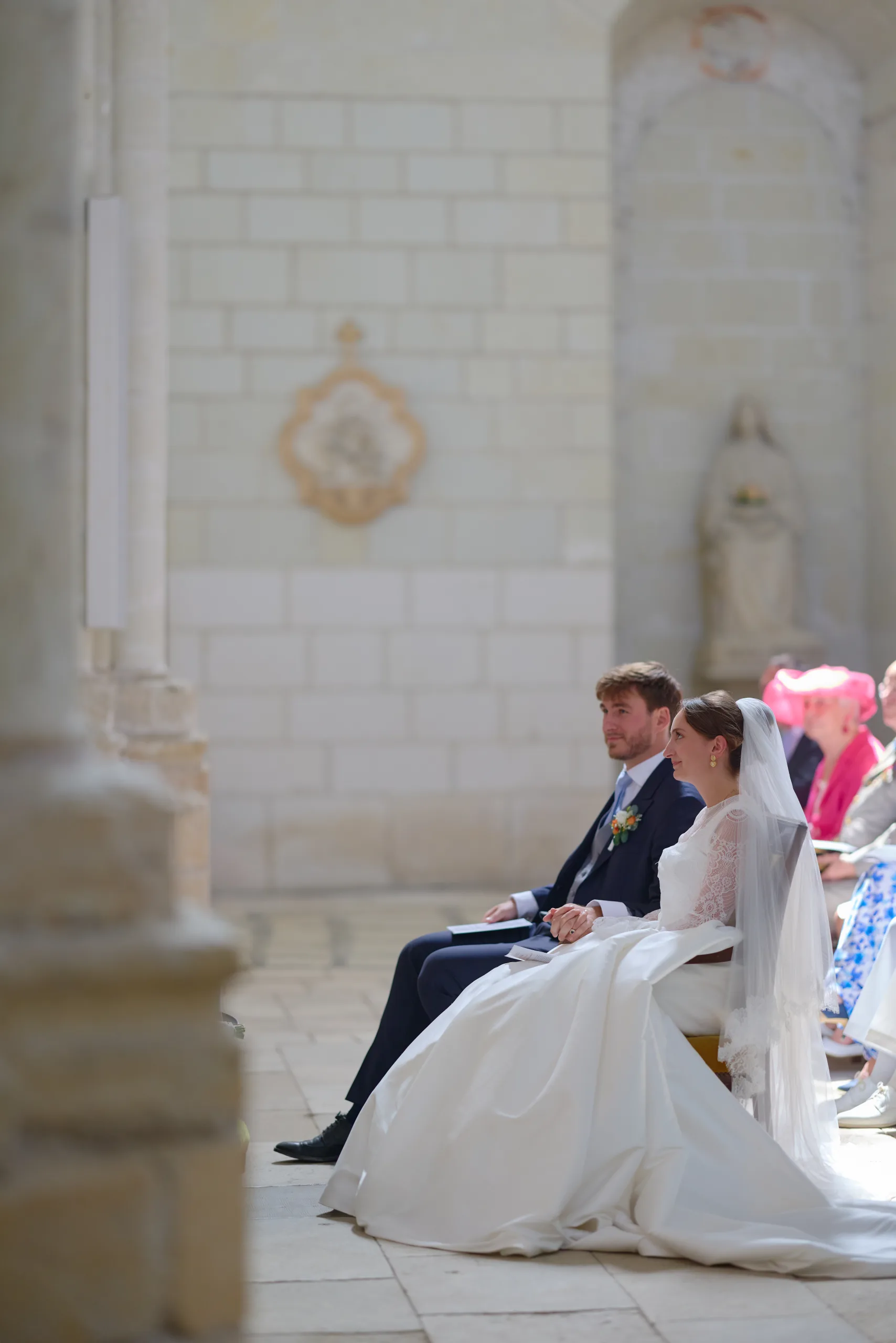 Femme en robe blanche agenouillée devant l’autel