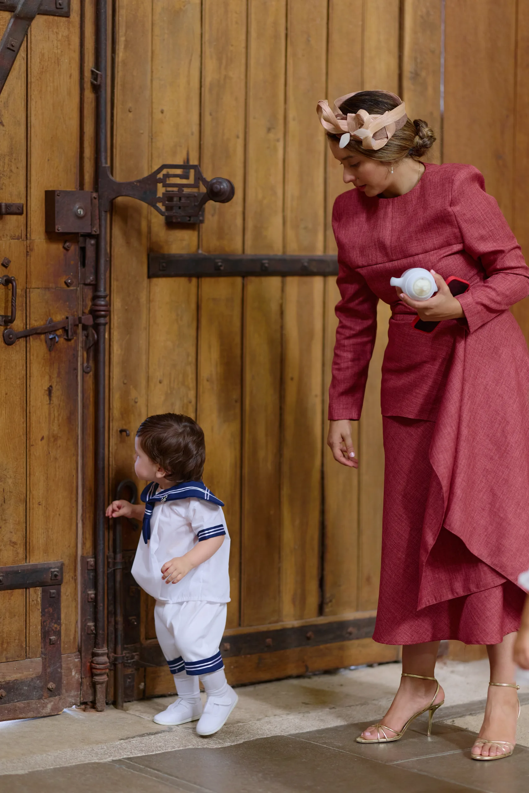 Un adulte et un enfant devant une grande porte en bois