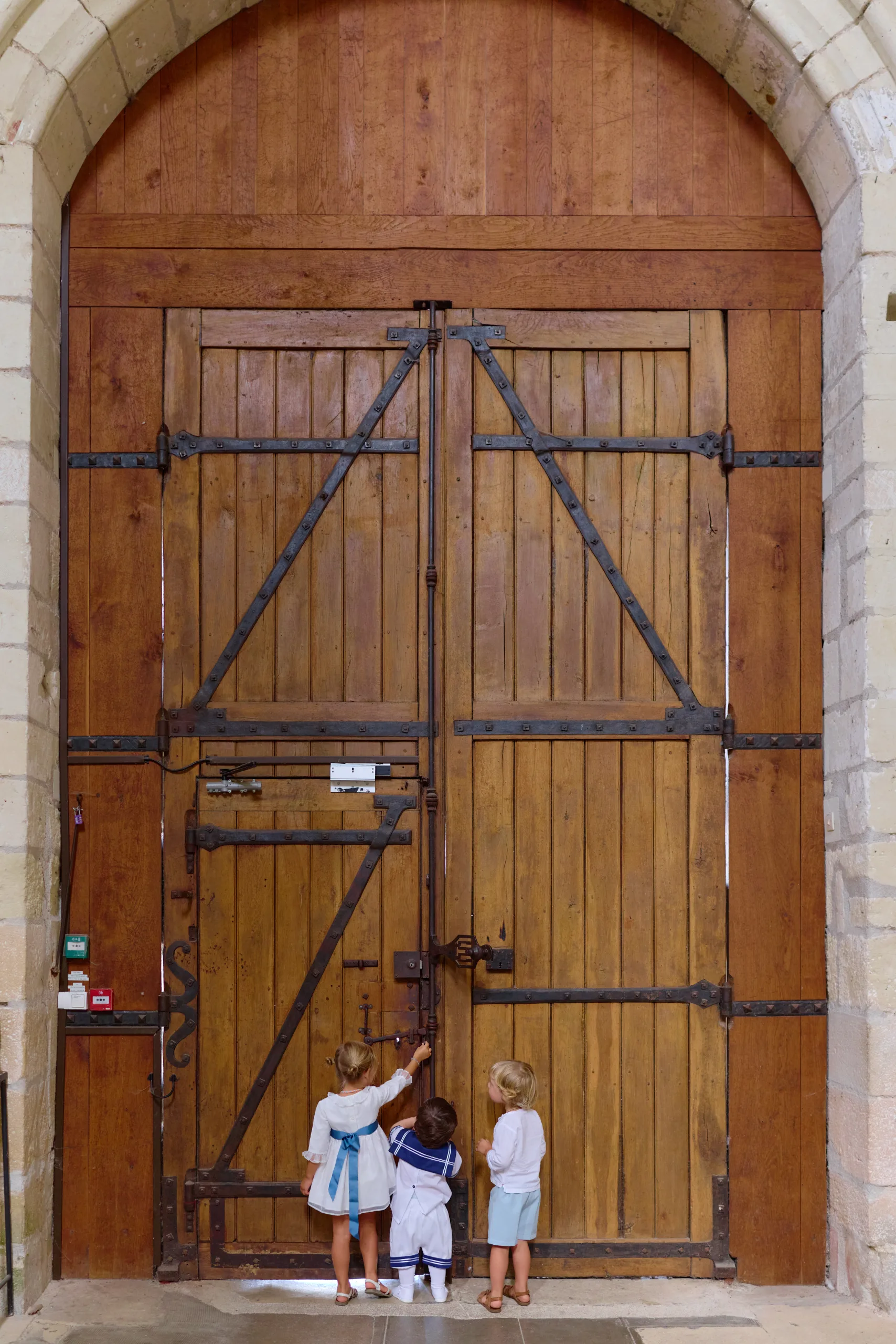 Deux enfants devant la grande porte de l’église