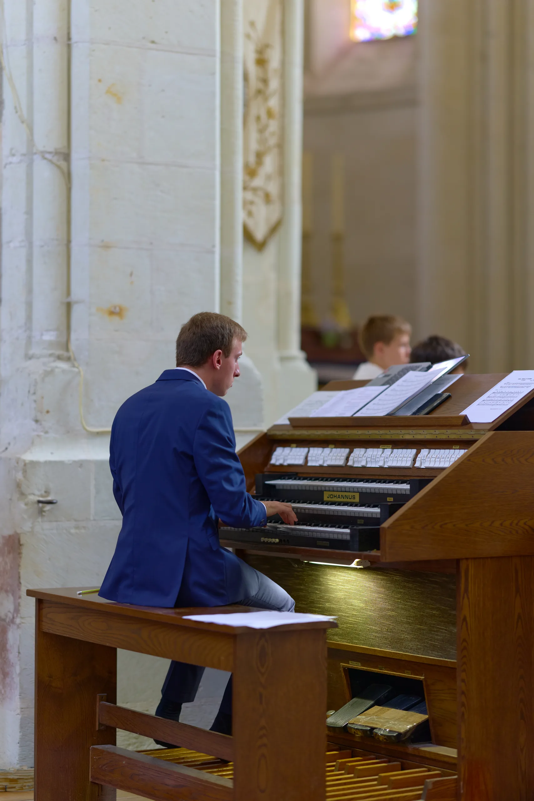 Homme en costume jouant du piano dans l’église