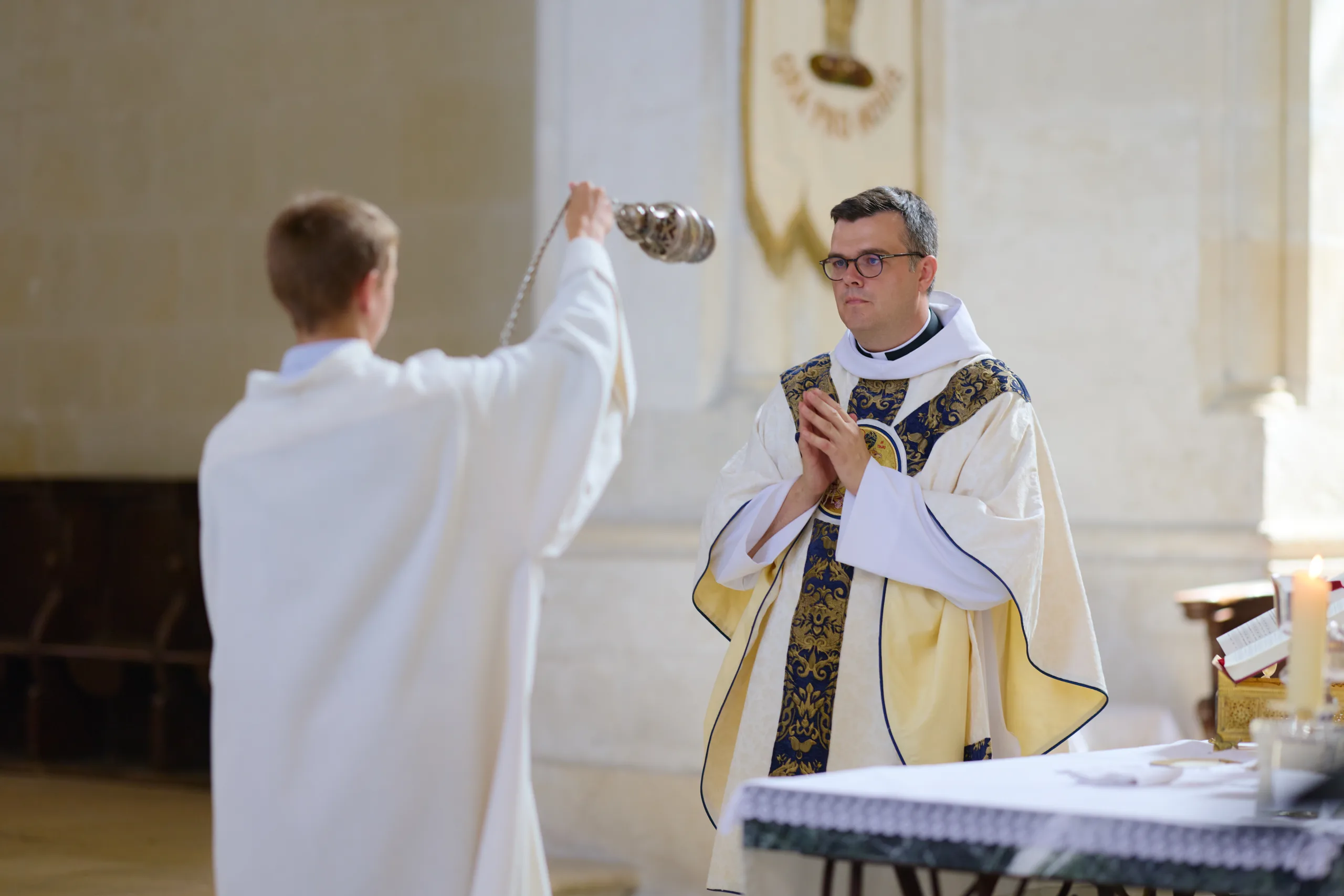 Prêtre élevant un objet liturgique pendant la messe