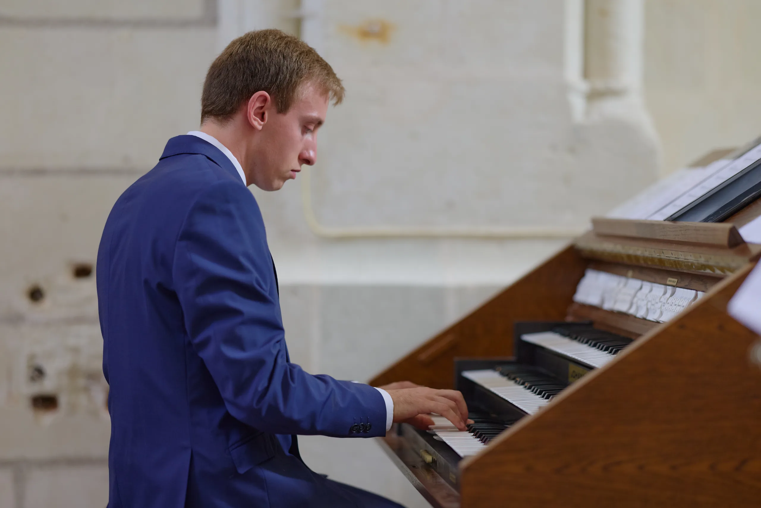 Homme en costume jouant du piano