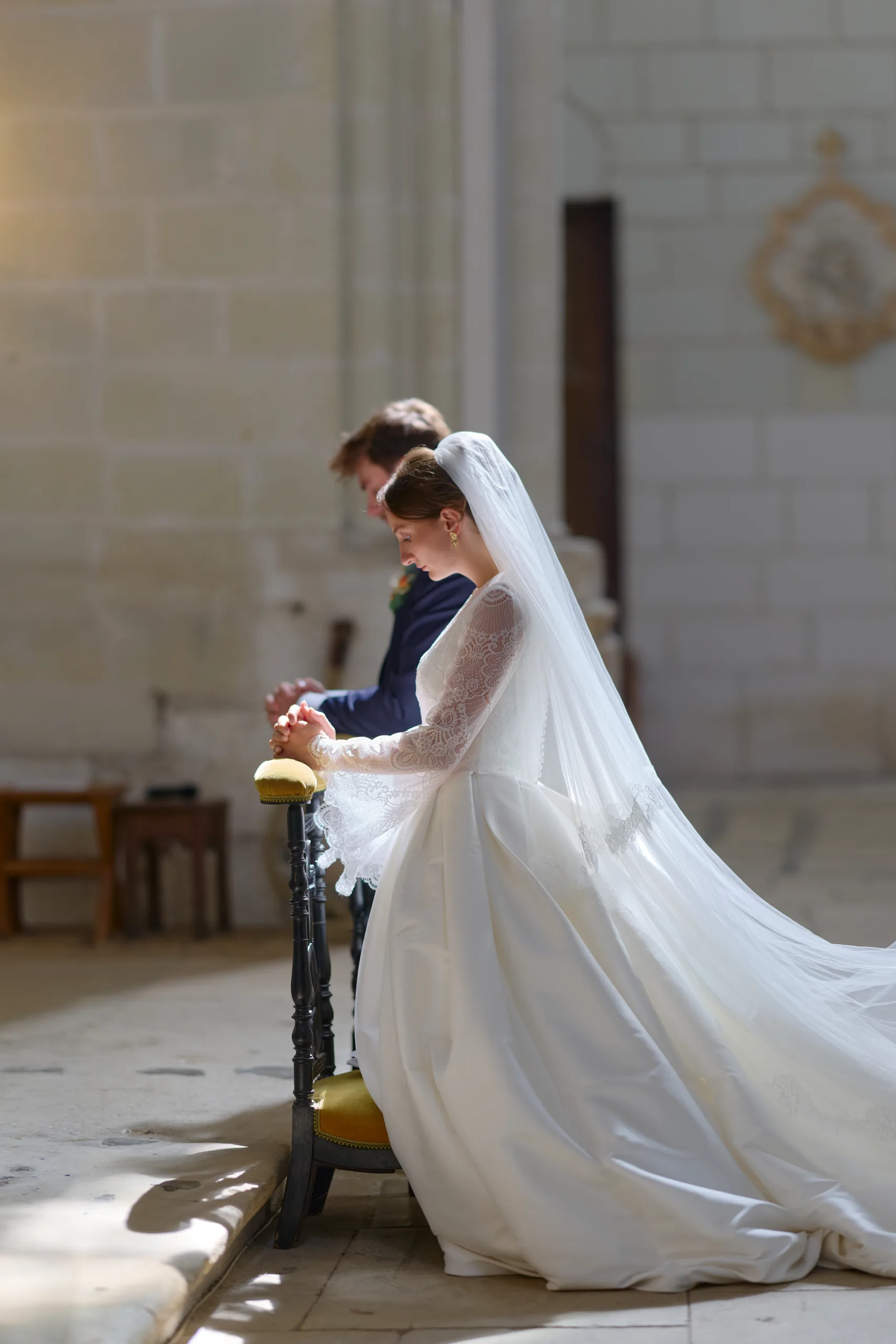 Femme en robe blanche agenouillée devant l’autel