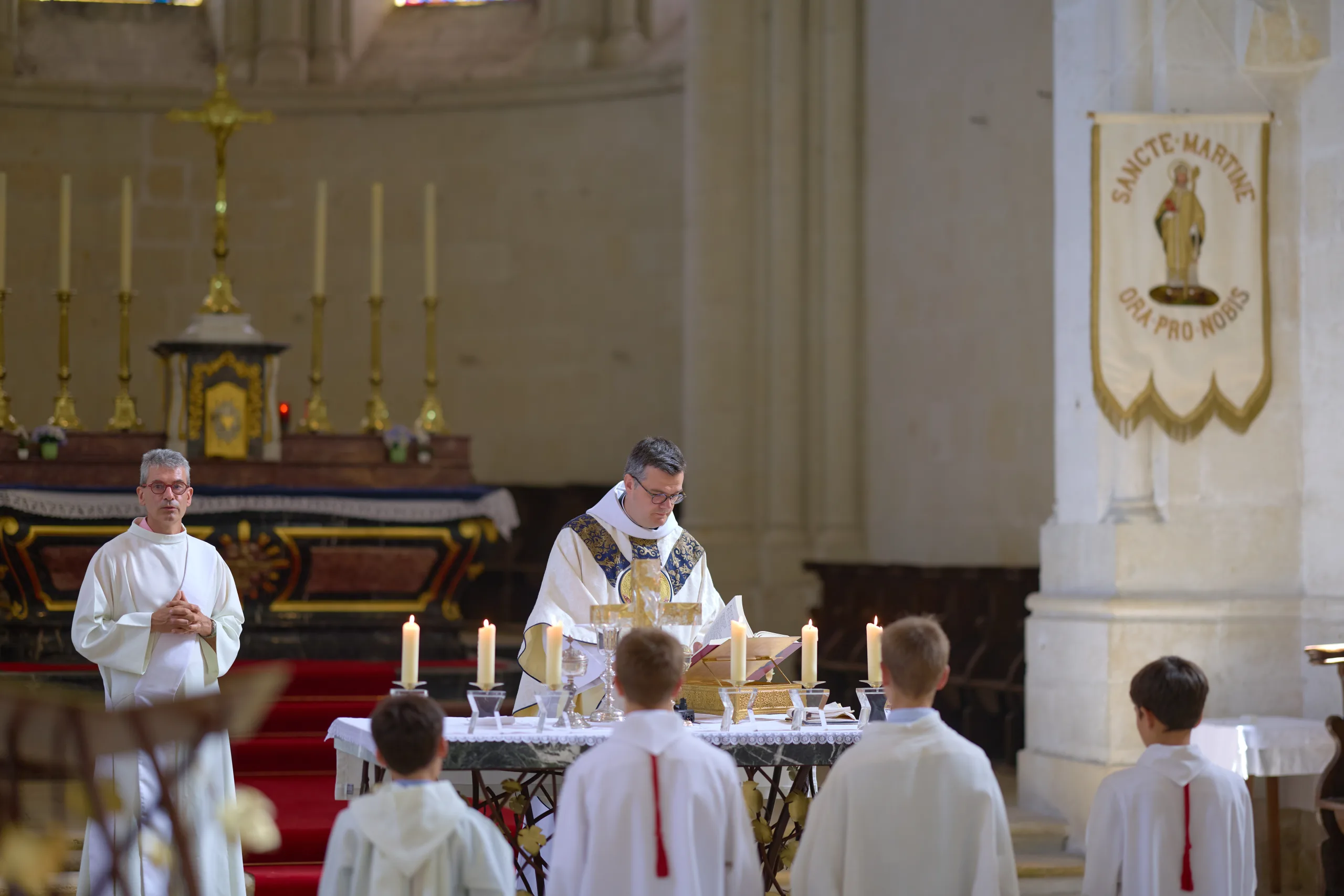 Prêtres célébrant la messe devant les enfants de chœur