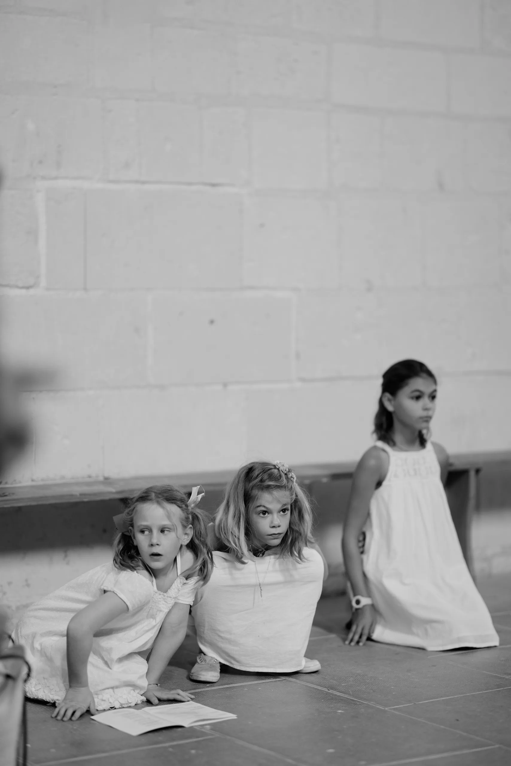 Des enfants assis pendant la cérémonie, en noir et blanc