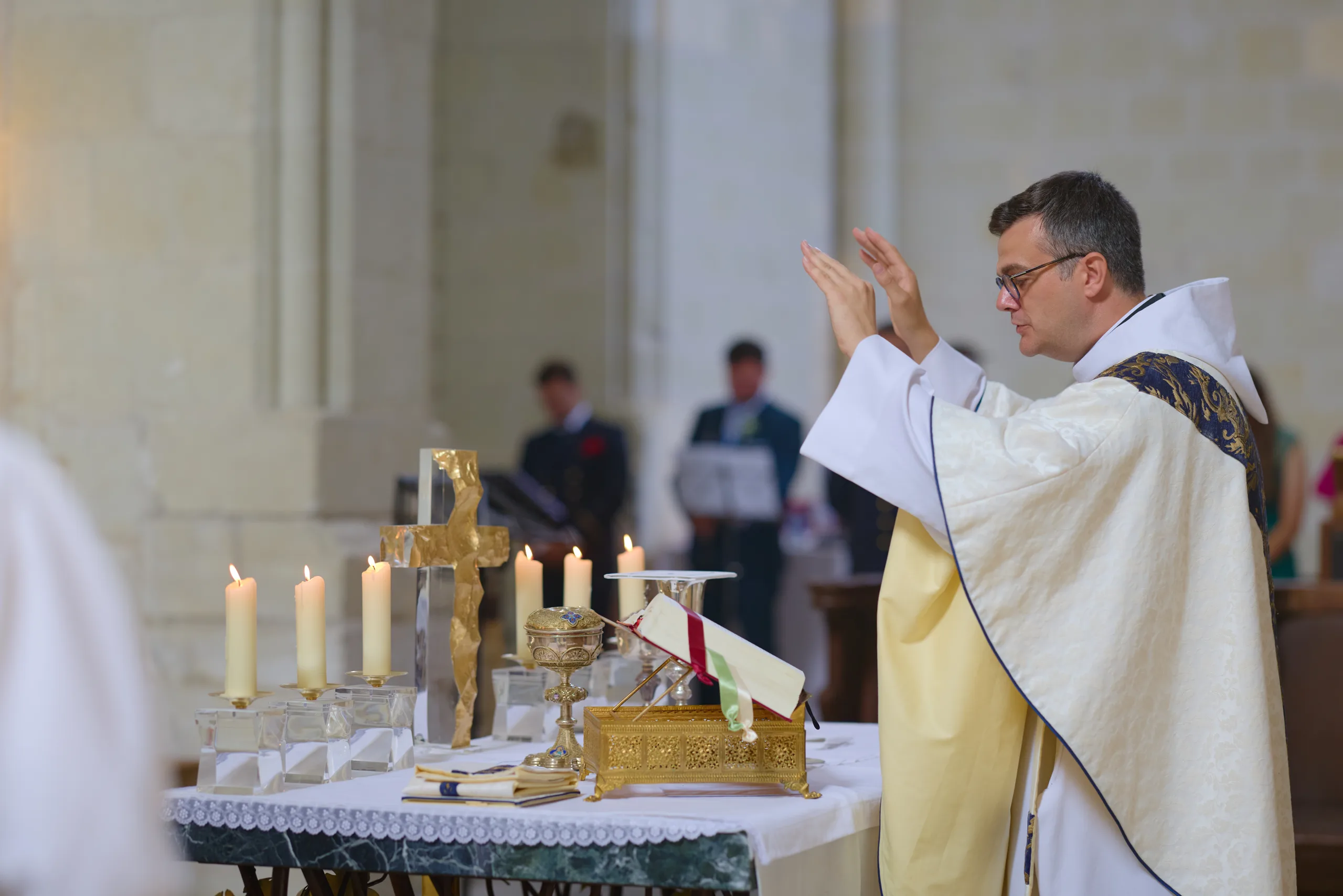 Prêtre levant les mains devant l’autel