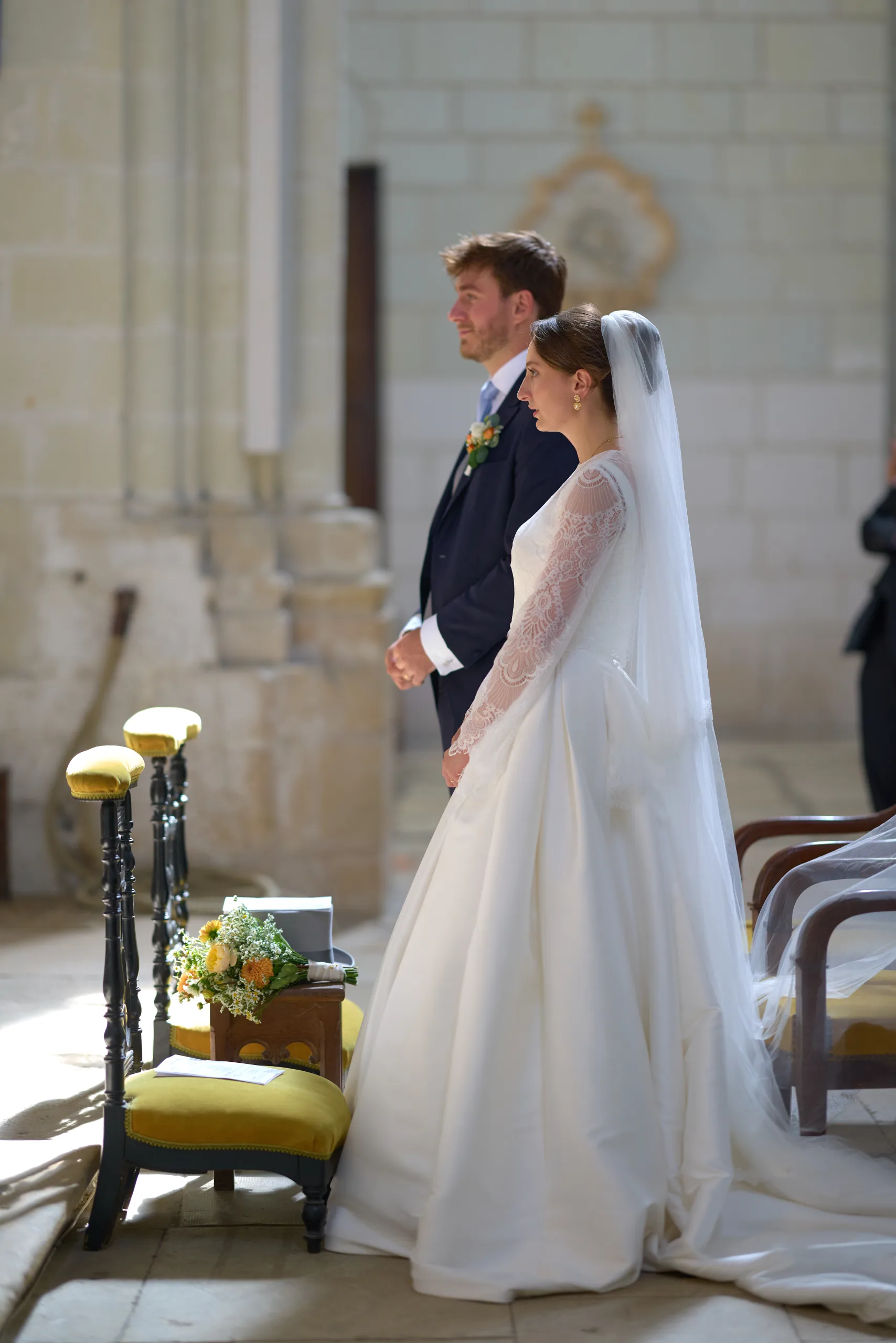 Femme en robe blanche près d’une chaise devant l’autel