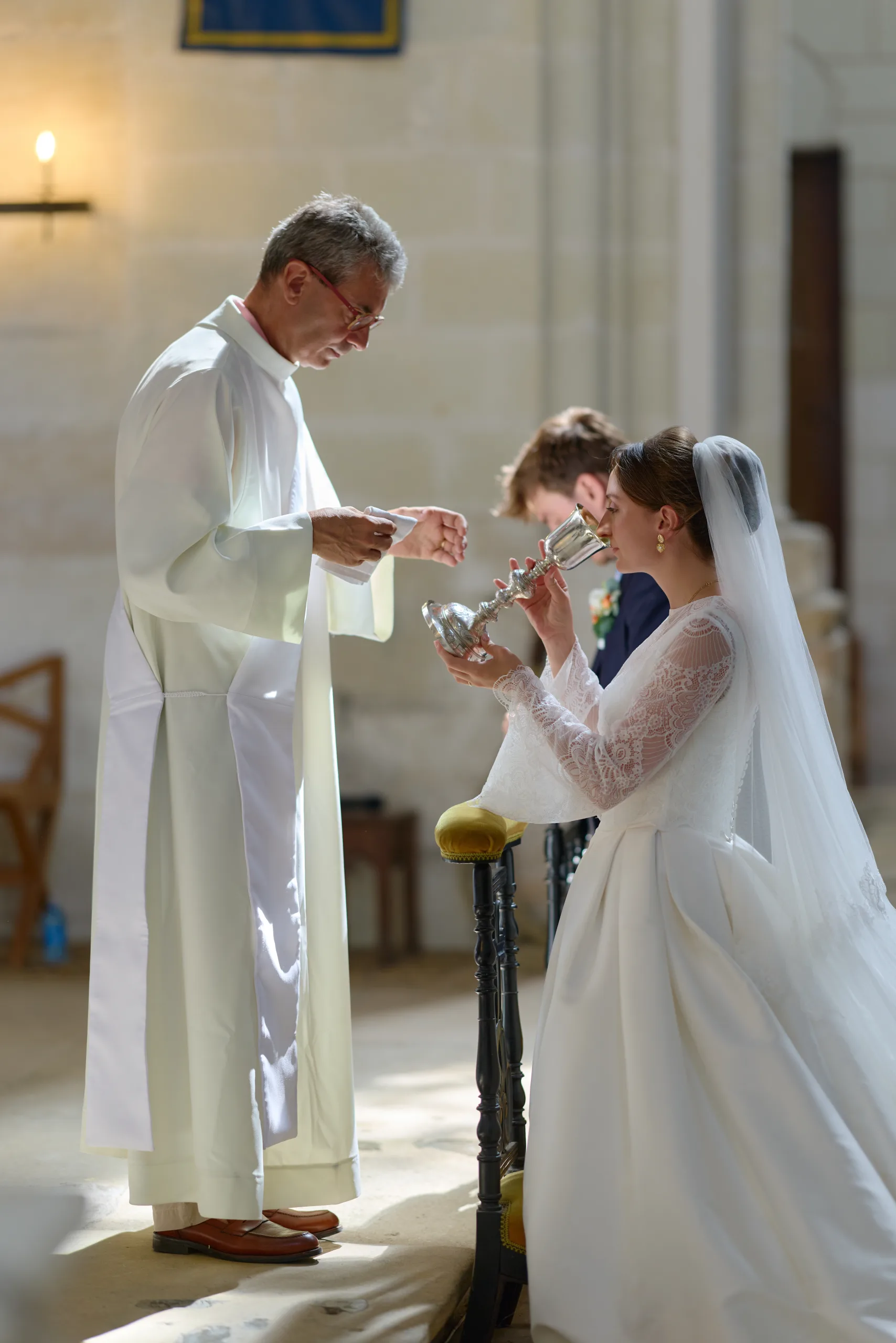 Prêtre donnant la communion à une femme agenouillée