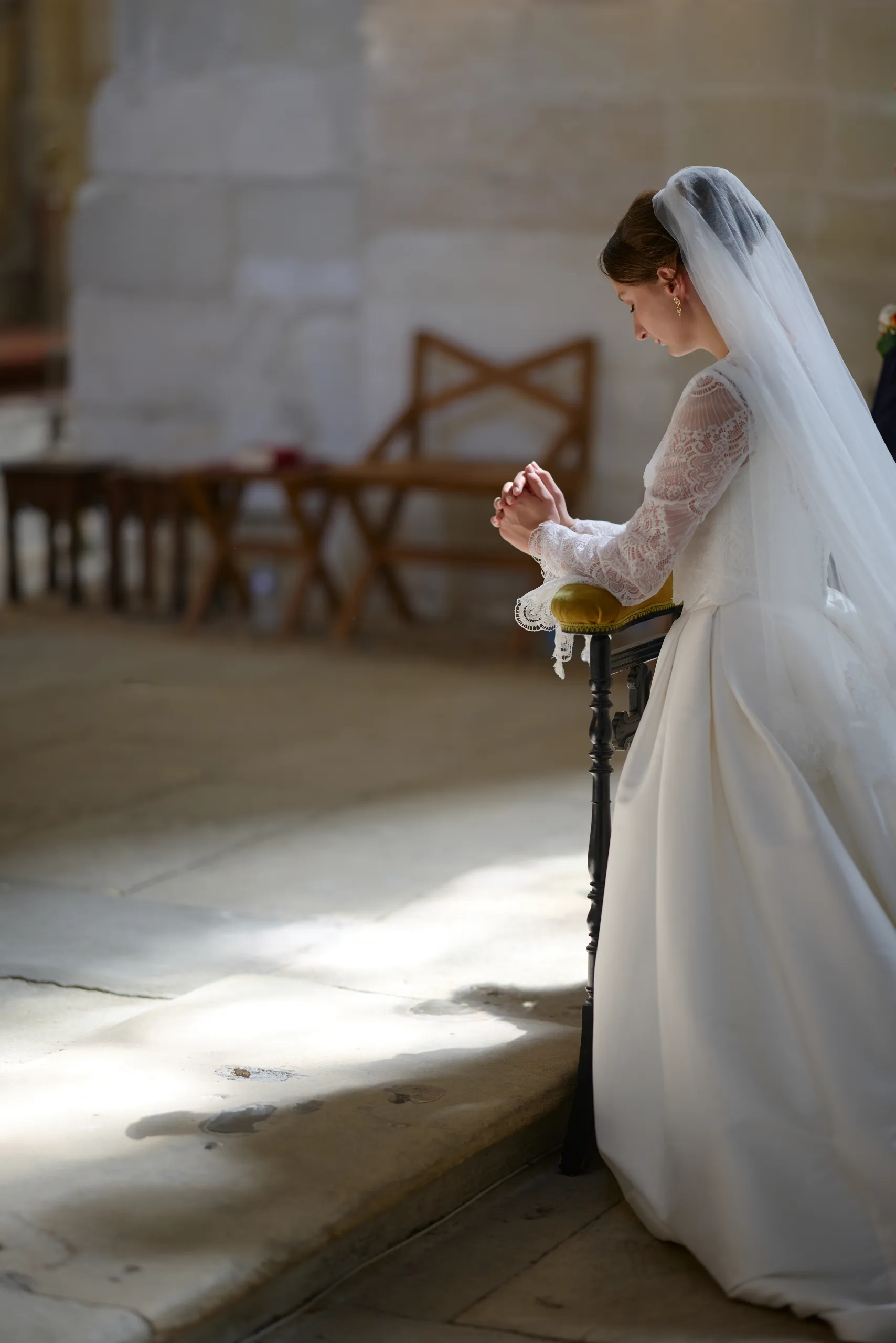 Femme en robe blanche agenouillée près de l’autel