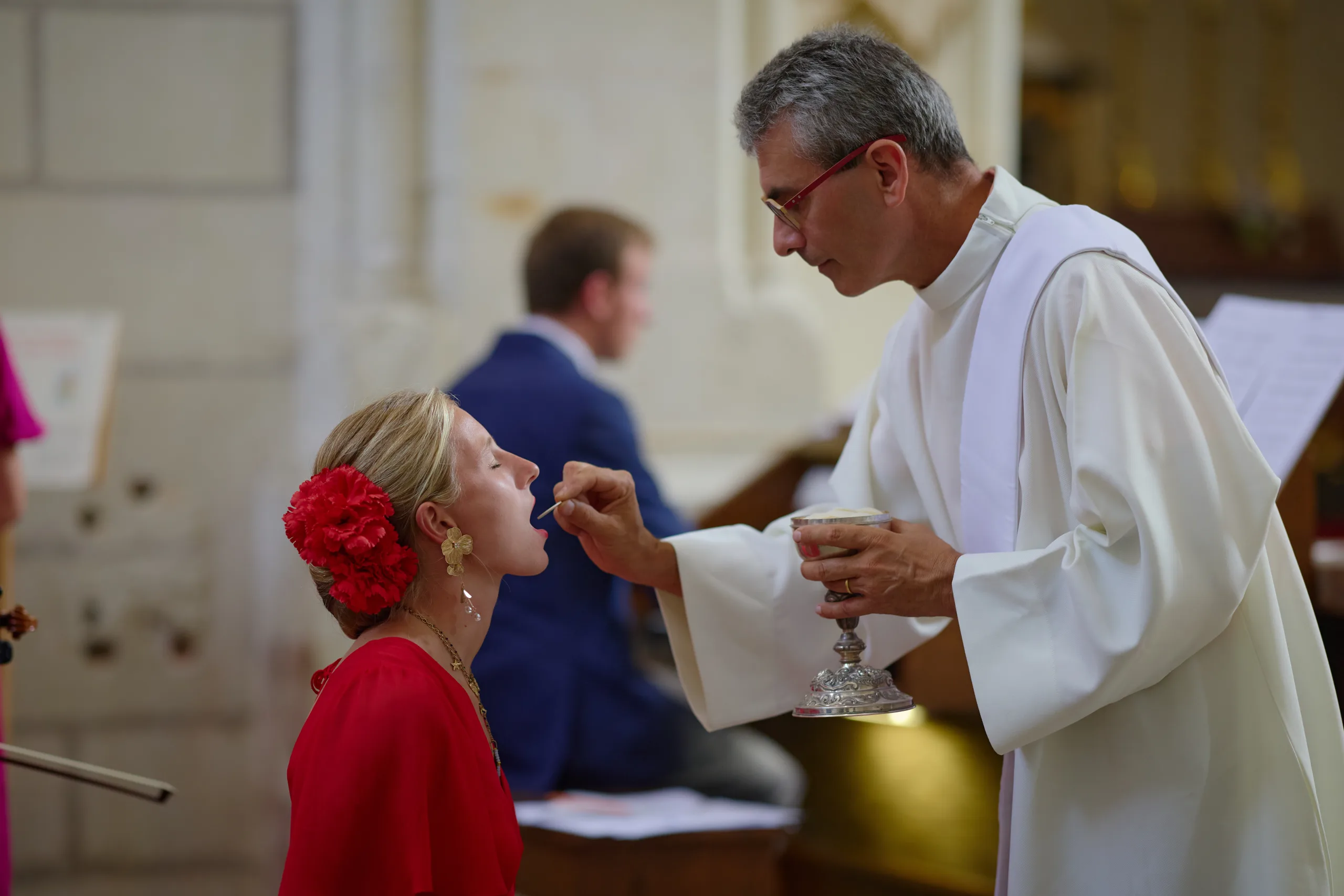Prêtre donnant la communion à une femme