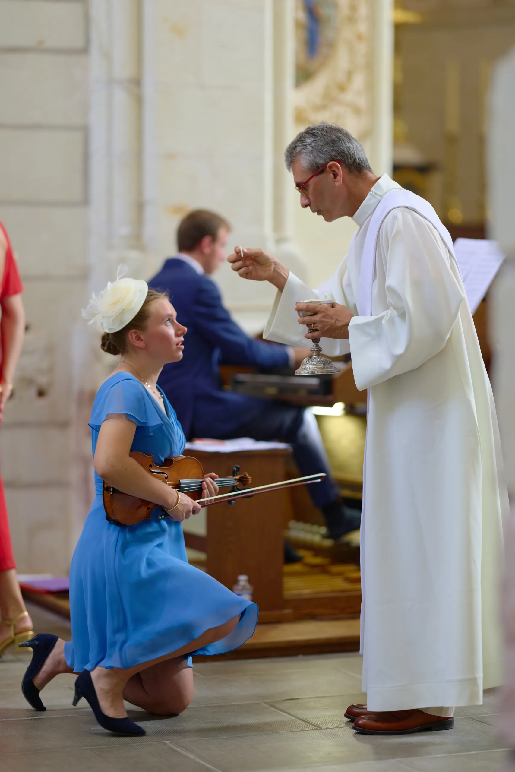Prêtre donnant la communion à une femme agenouillée