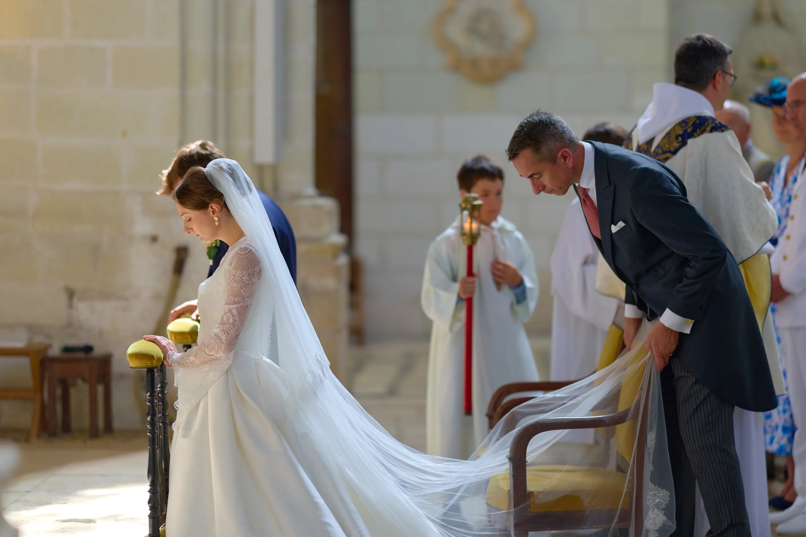 Femme en robe blanche agenouillée devant l’autel