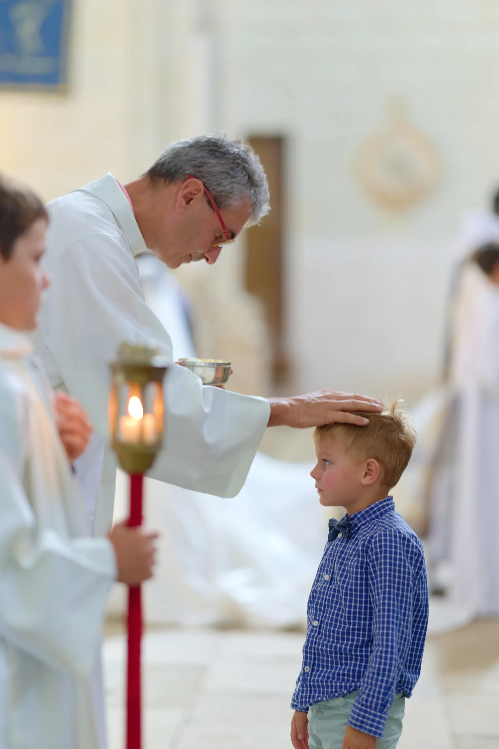 Prêtre donnant la communion à un enfant