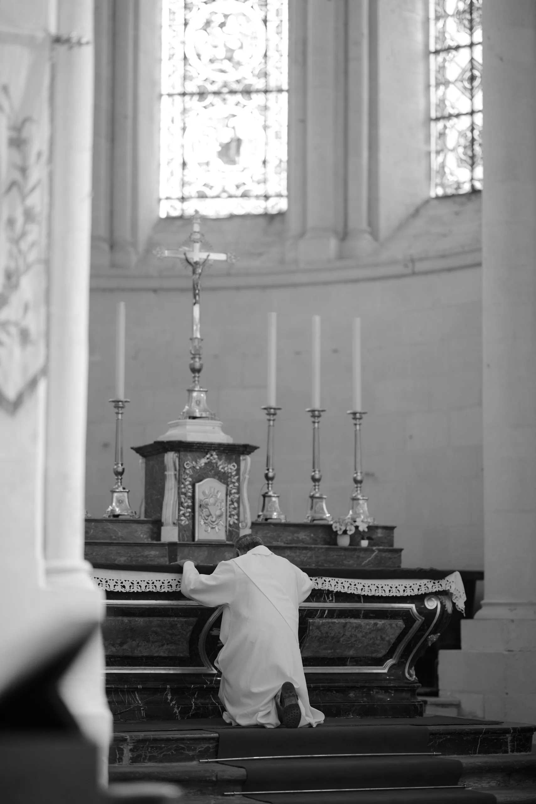 Femme agenouillée devant l’autel, en noir et blanc