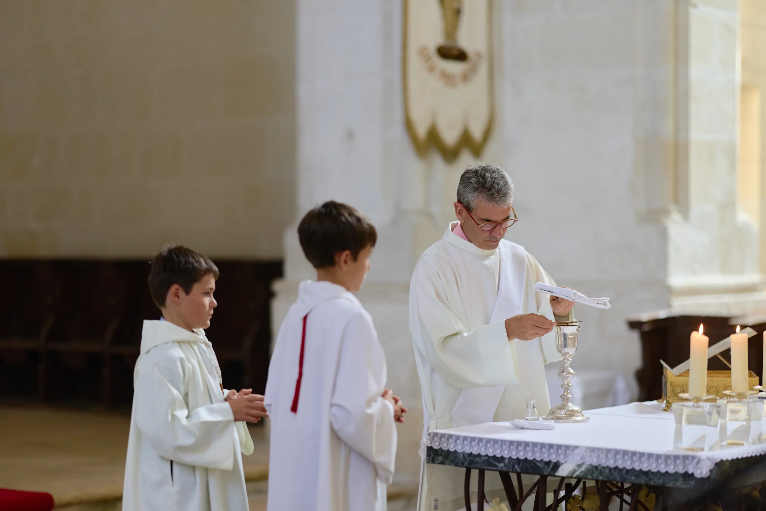 Prêtre entouré de deux enfants de chœur