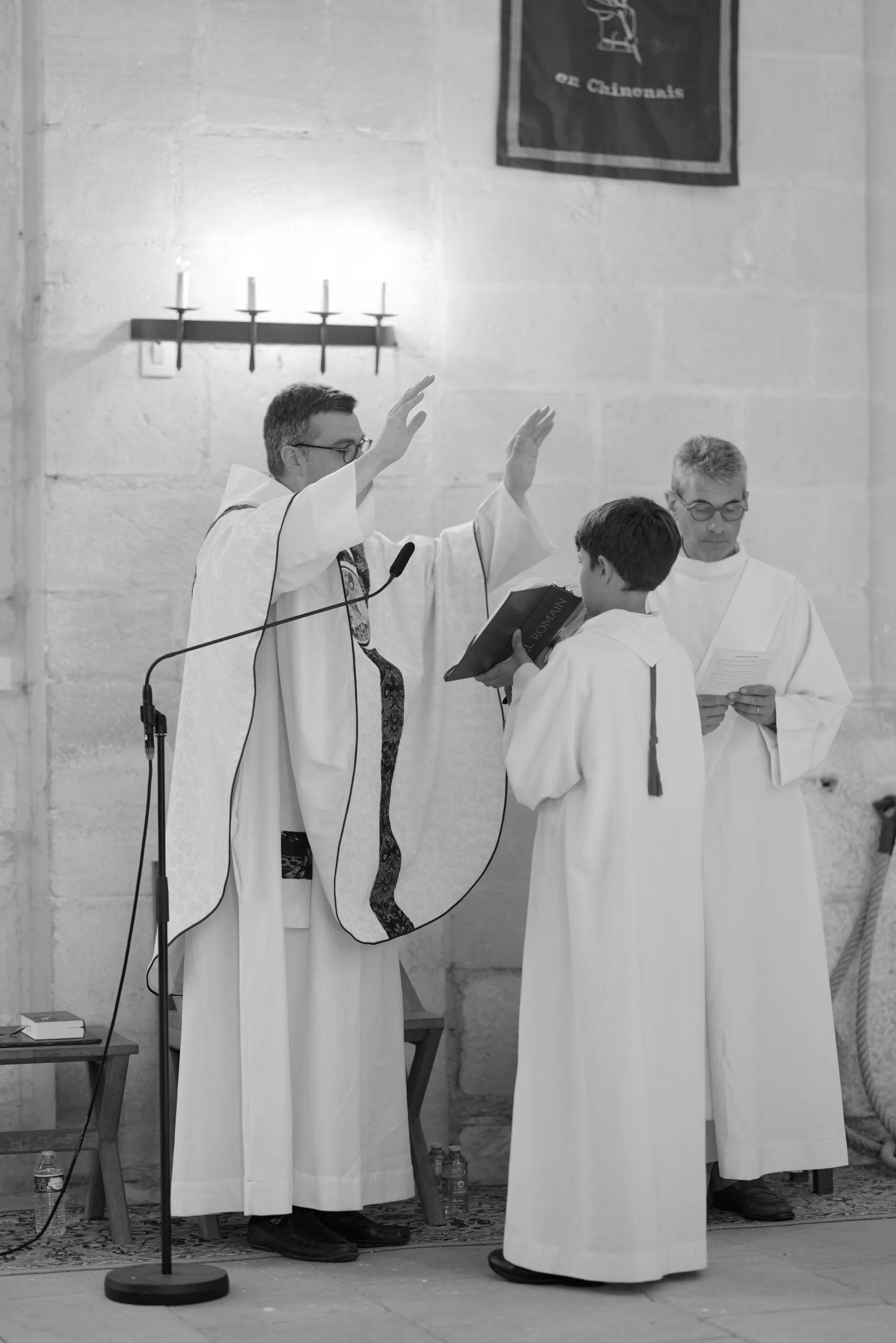 Prêtres et enfants de chœur dans l’église, en noir et blanc