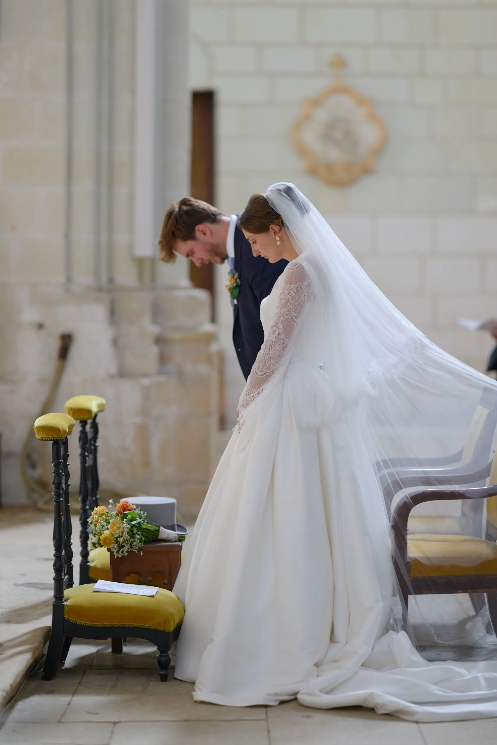 Une femme en robe blanche agenouillée près de l’autel