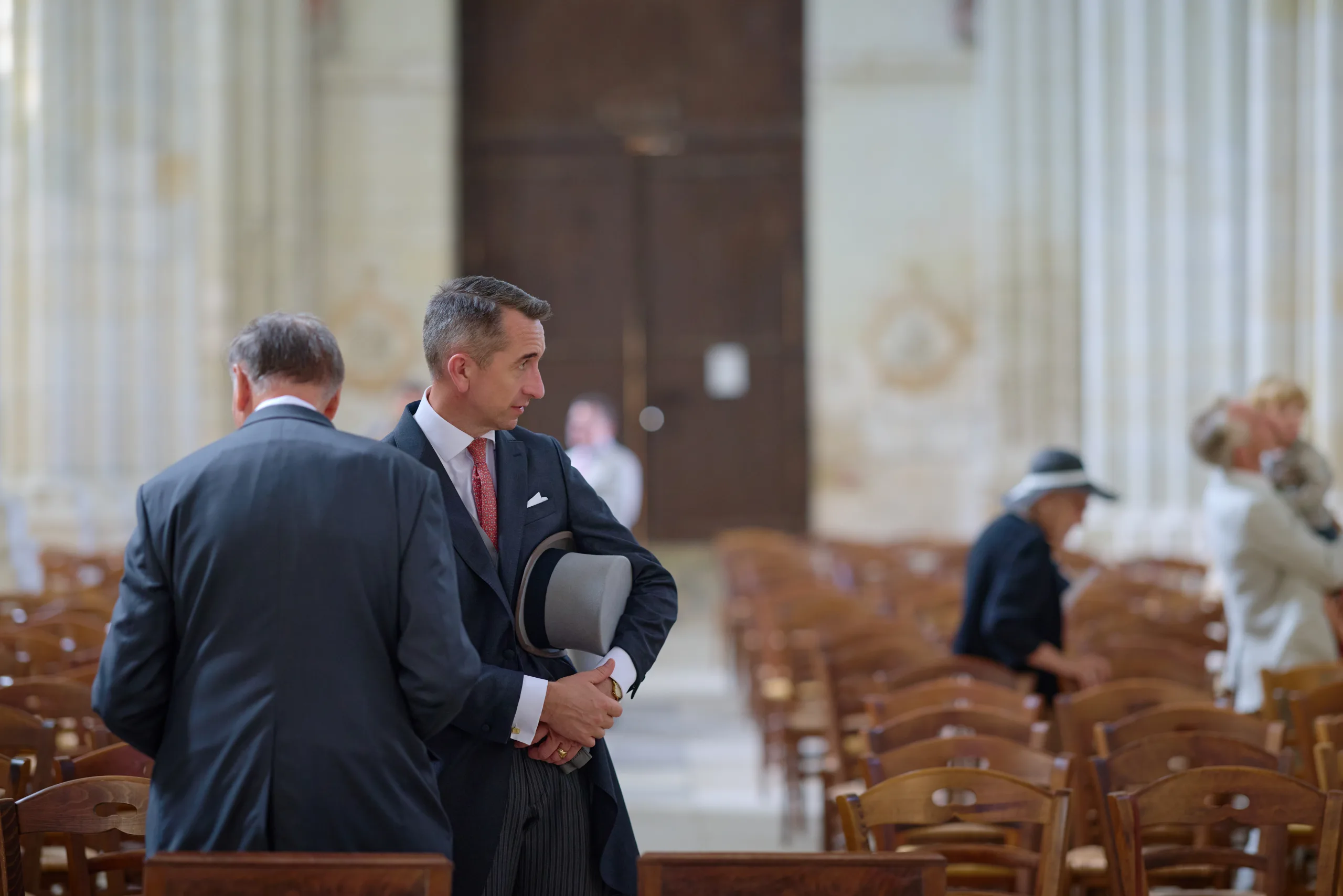 Deux hommes discutant entre les rangées de chaises