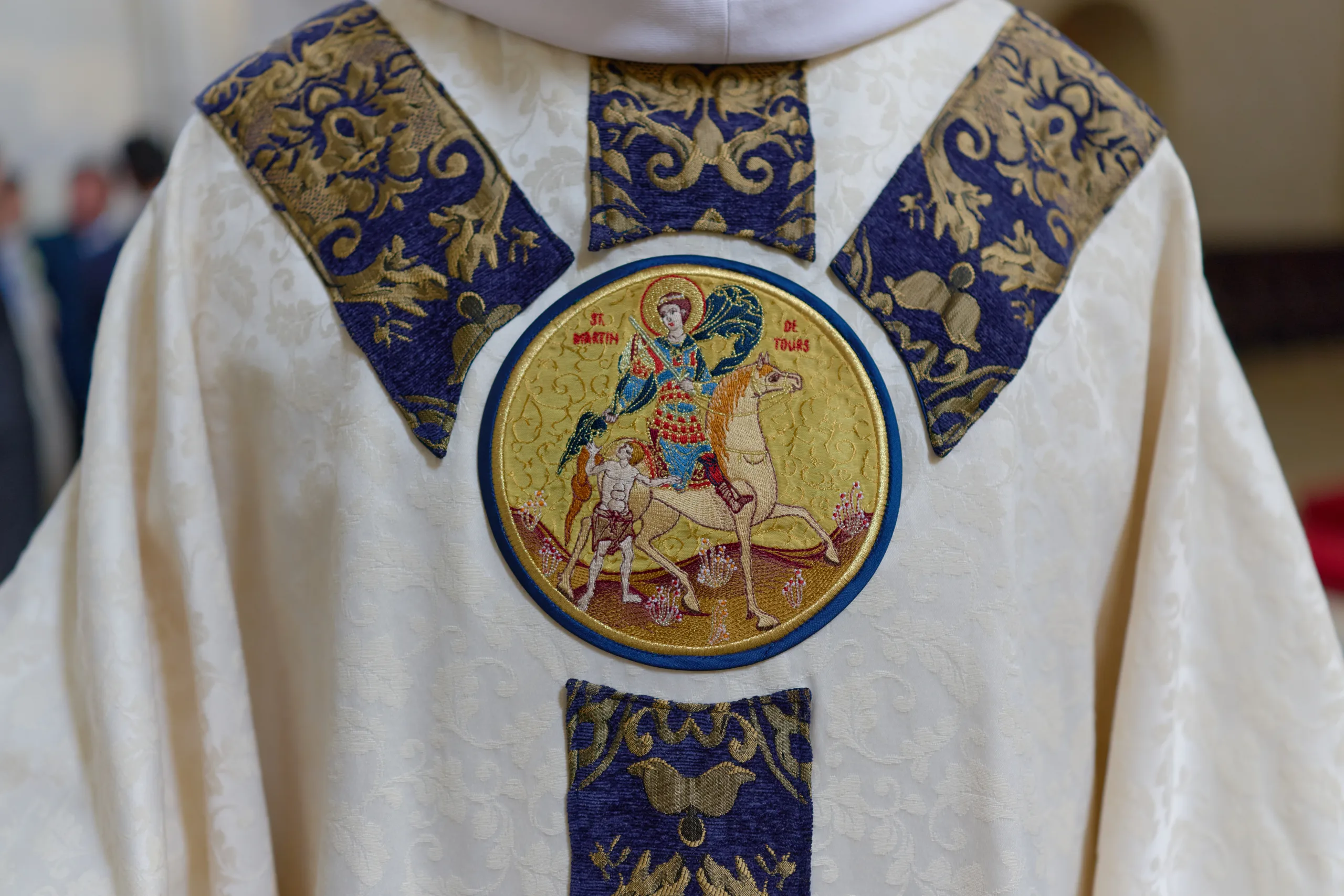 Détail d’une chasuble blanche brodée de bleu et d’or