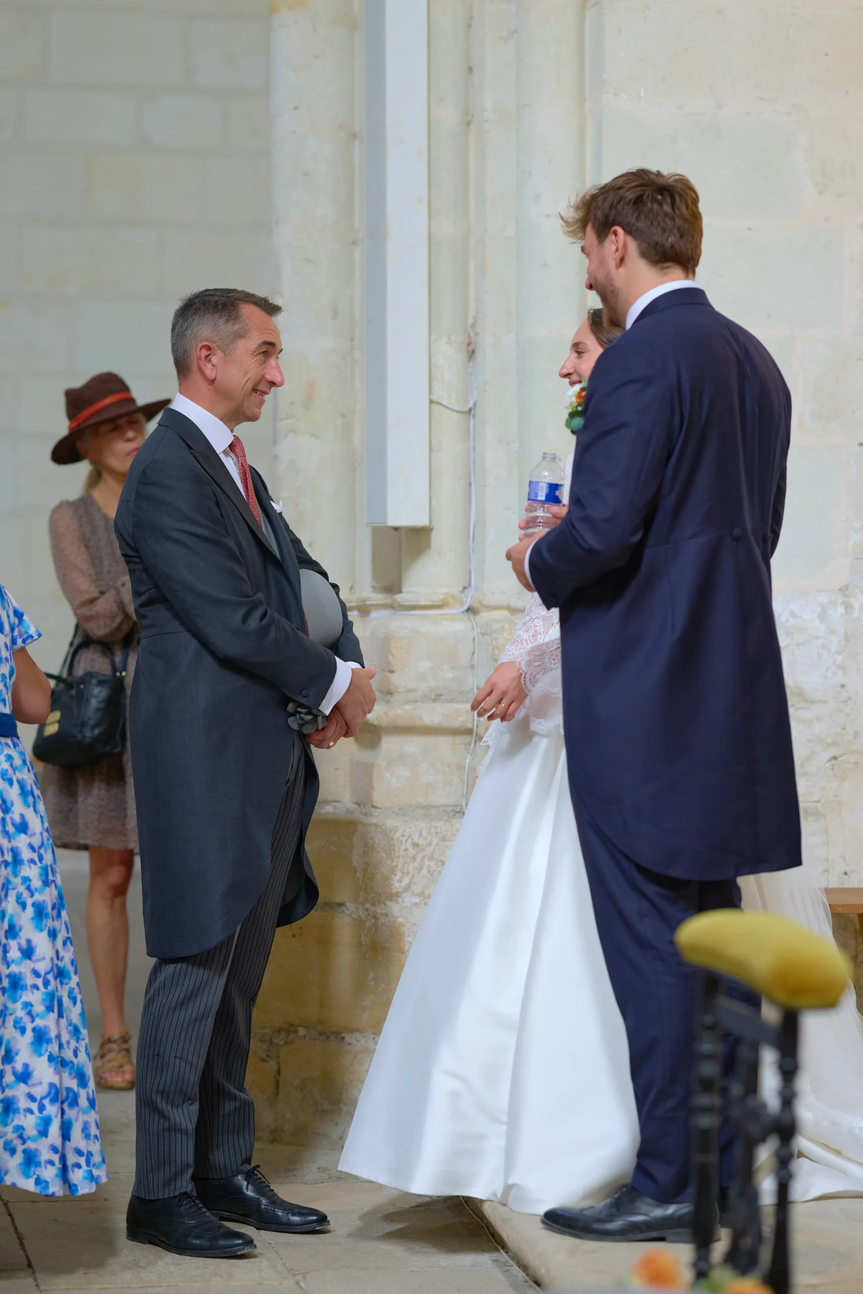 Deux hommes discutent près de la mariée dans l’église