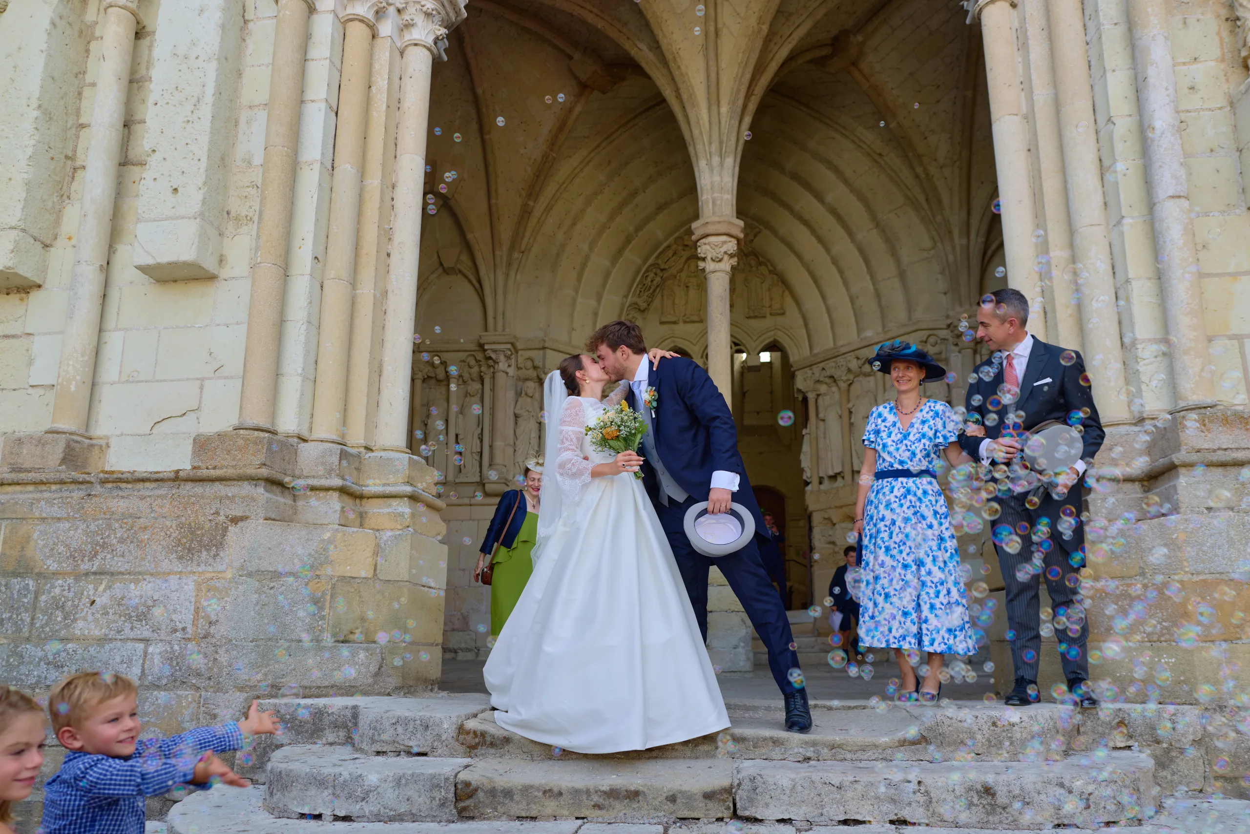Les mariés s’embrassent sur les marches de l’église