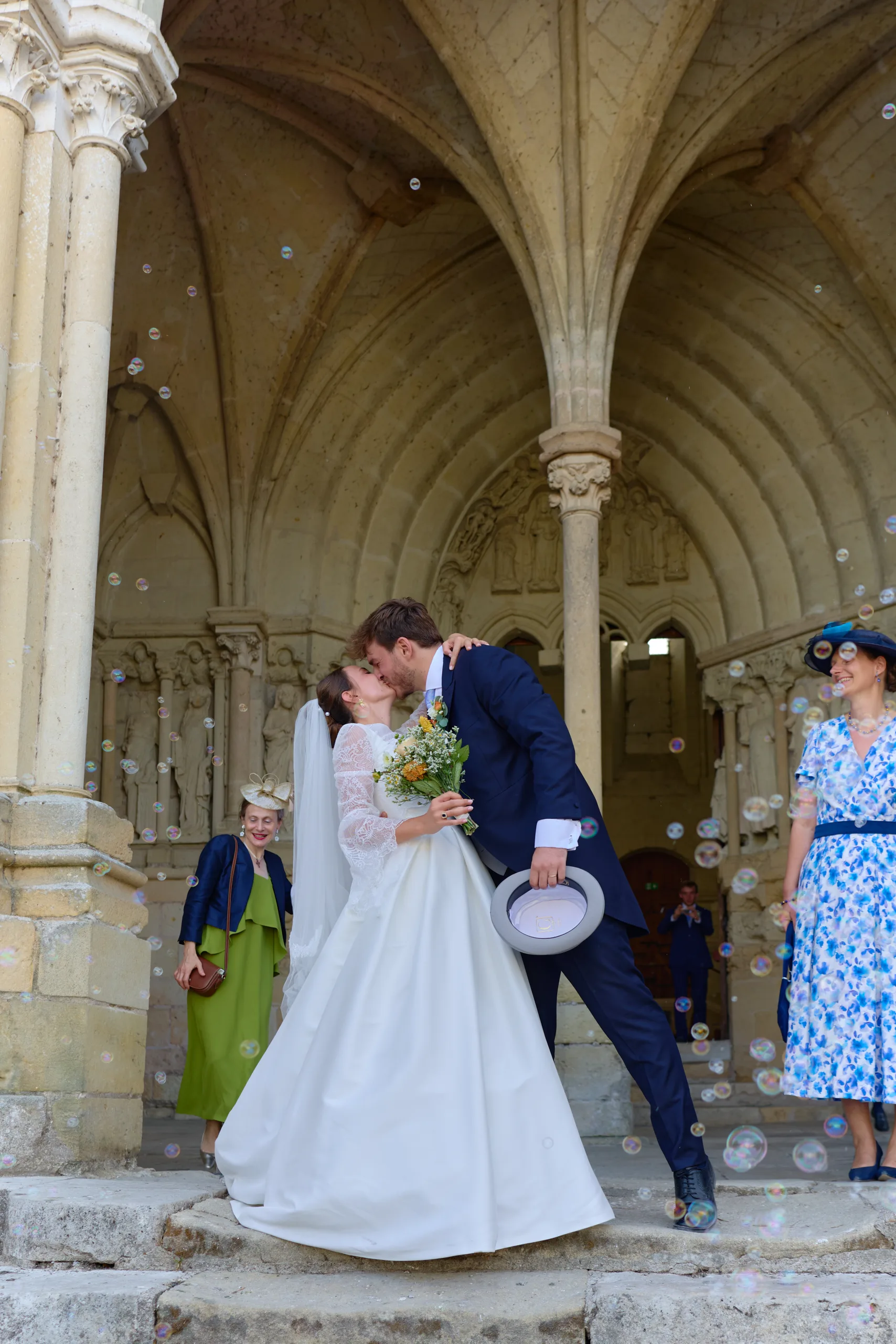 Le marié embrasse la mariée sur les marches de l’église