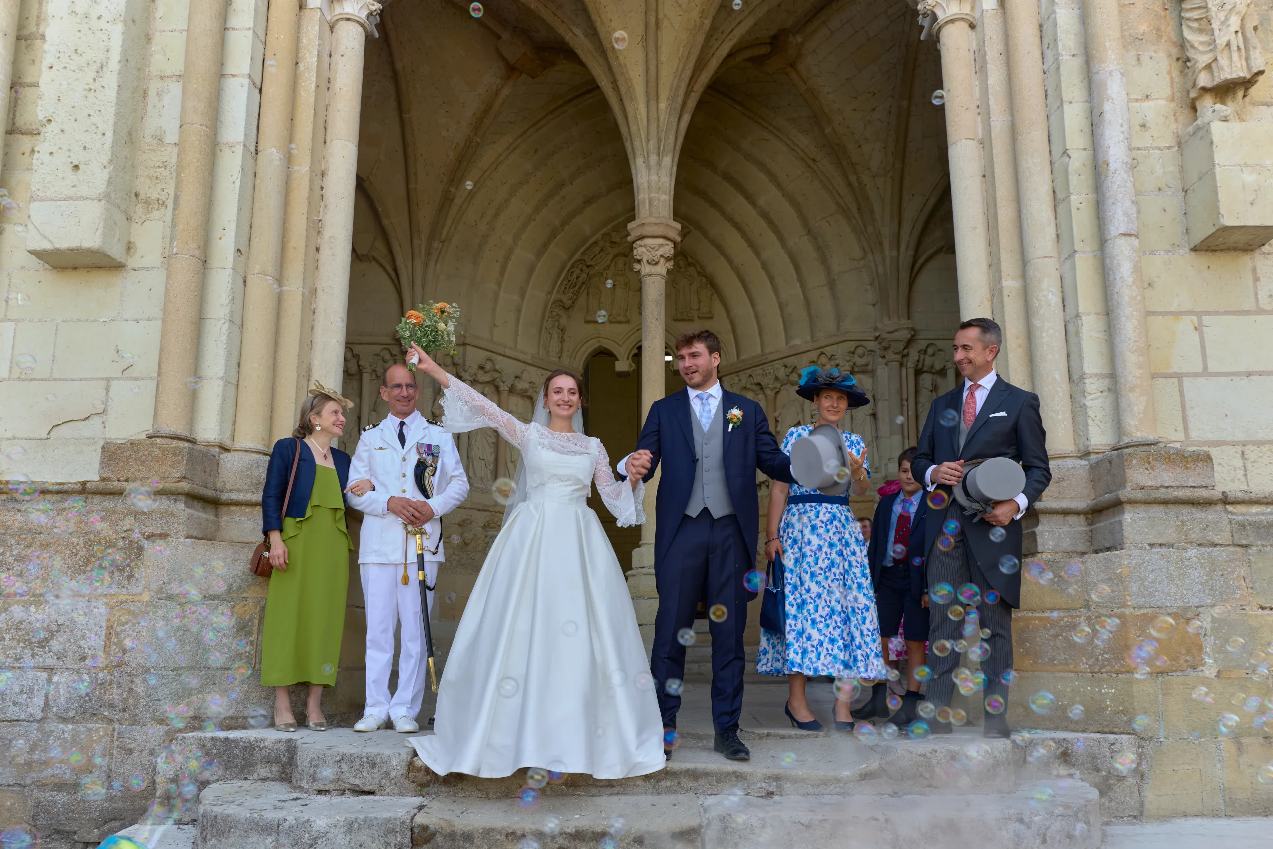Les mariés et leurs invités posent sur les marches de l’église