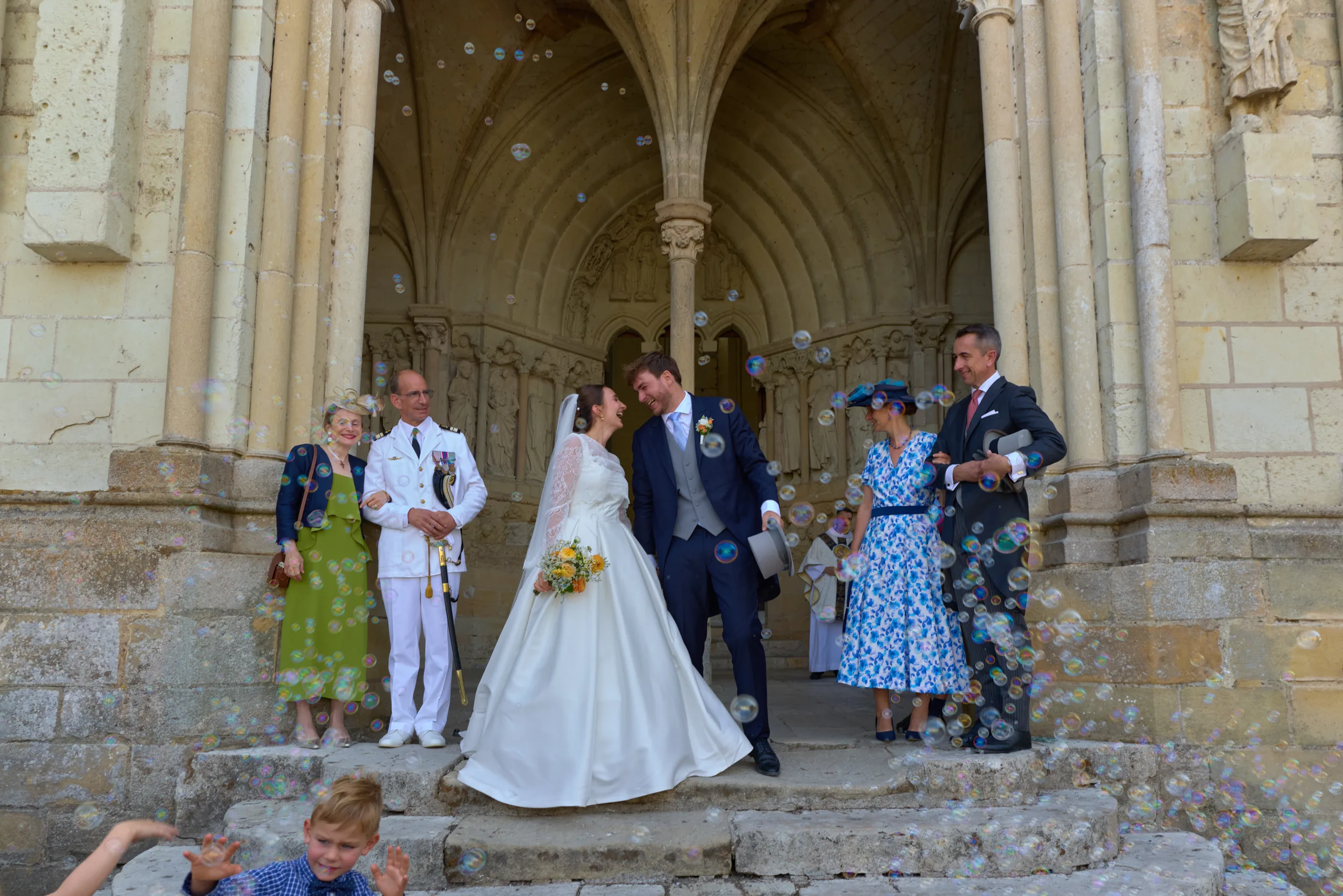 Les mariés s’embrassent parmi leurs invités devant l’église