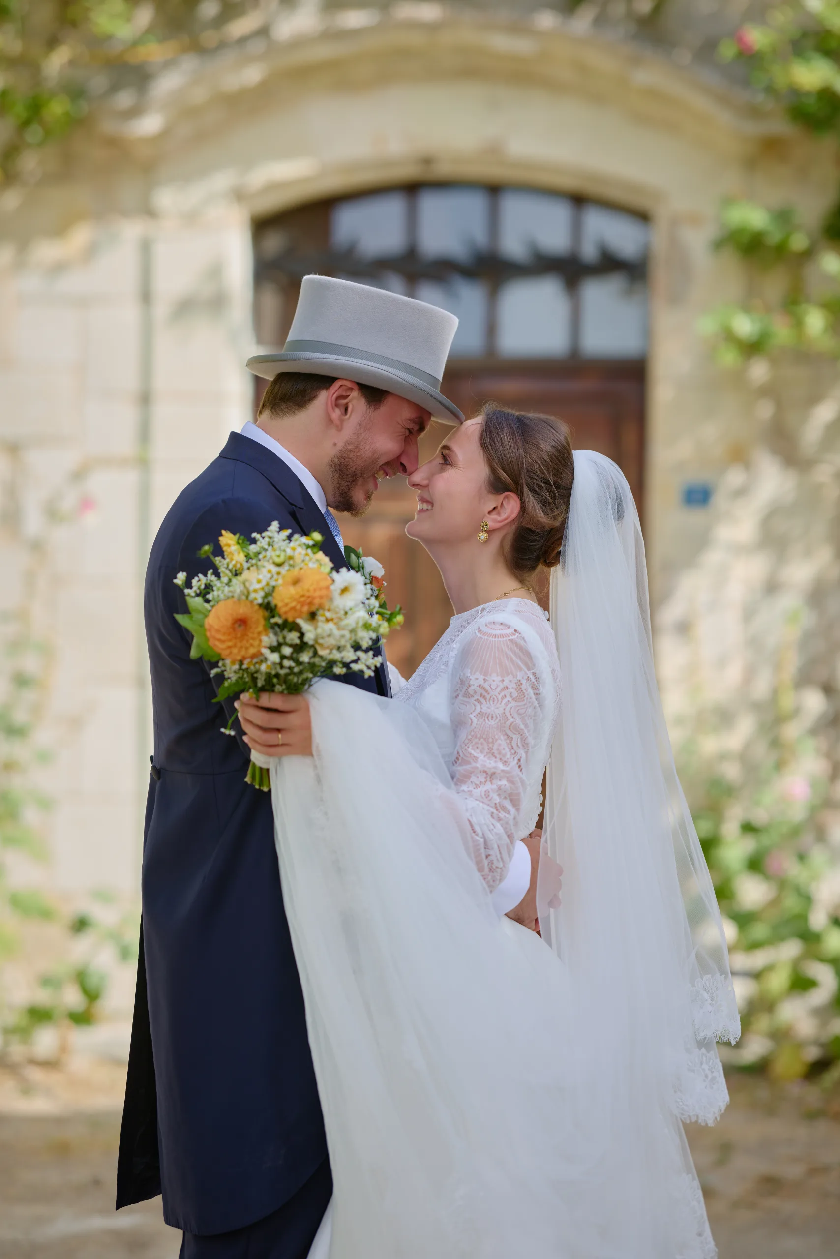 Les mariés s’embrassent avec le bouquet entre eux