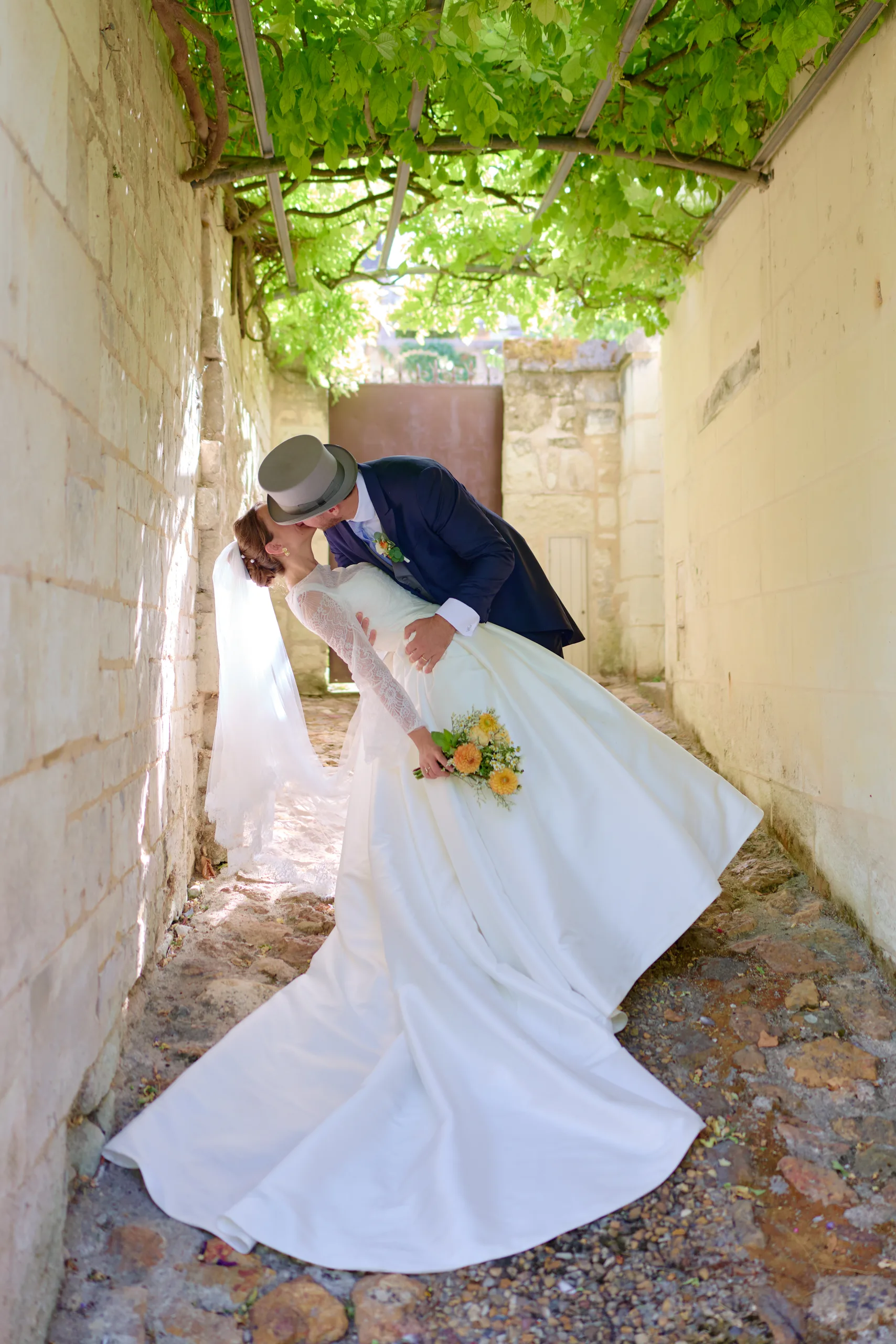 Le marié fait tourner la mariée dans un passage ombragé